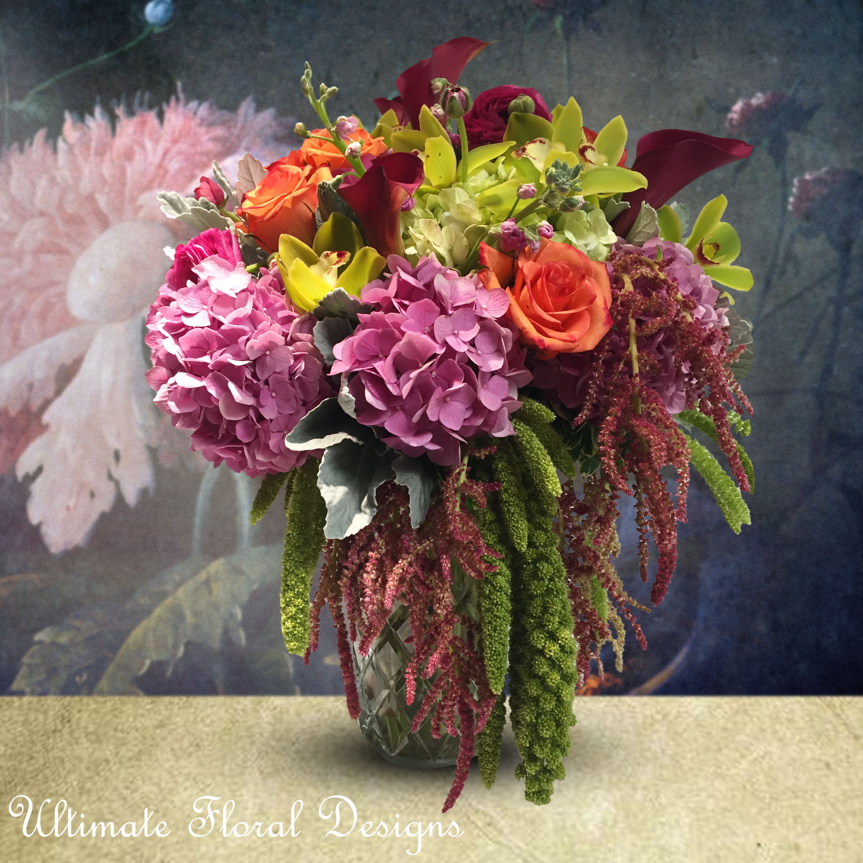 Vibrant Bloom Vibrant Bloom - Add a burst of color to your space with Vibrant Bloom by Ultimate Floral Designs. This lush silk and preserved arrangement showcases radiant hydrangeas, vibrant roses, exotic orchids, and elegant amaranthus. Perfect for those seeking premium silk floral arrangements, it brings bold beauty and lasting charm to any setting, making it an ideal centerpiece for events or home decor.