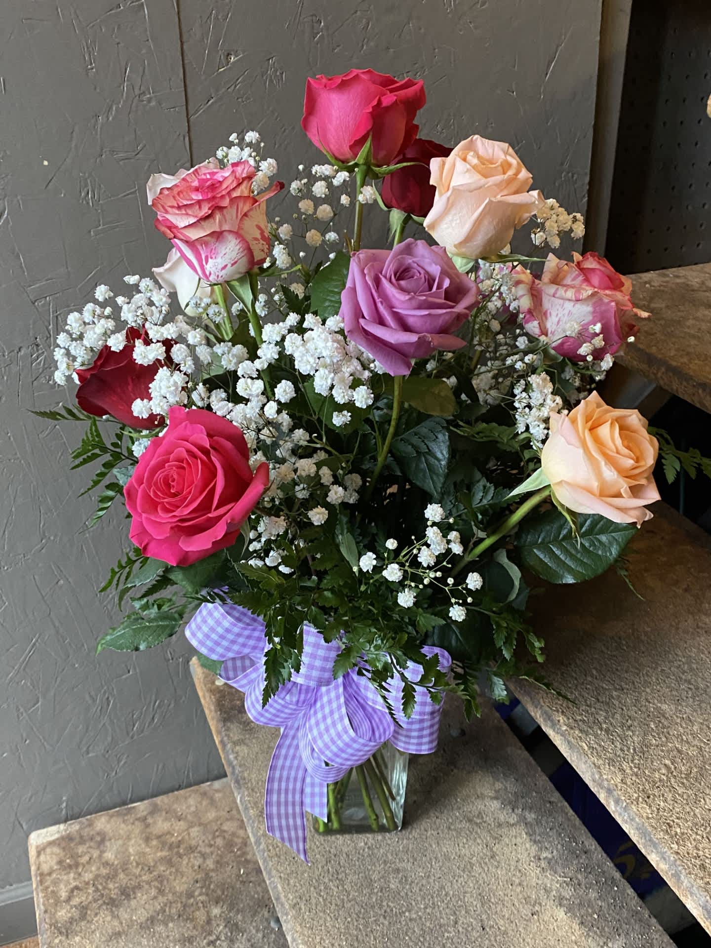 Mixed Color Dozen Roses Mixed Color Dozen Roses - A beautiful assortment of mixed color roses, with greenery and babies breath and a matching bow. All flowers, colors, vases, and ribbon may vary due to availability.
