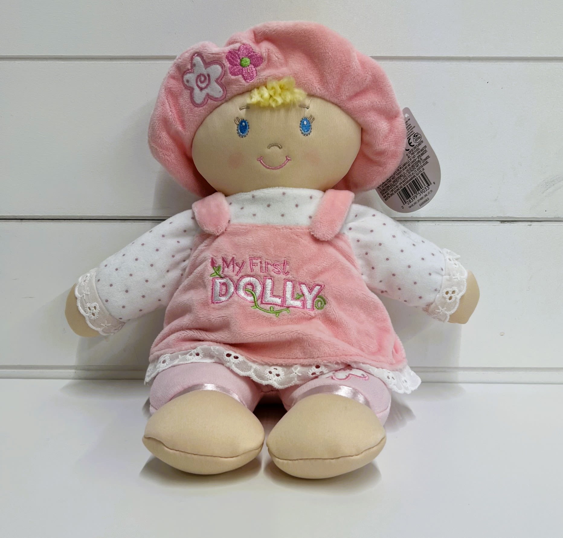 My First Dolly (LOCAL PICK UP AND DELIVERY ONLY) My First Dolly (LOCAL PICK UP AND DELIVERY ONLY) - This 13” soft baby doll wears a classic pink and white plush dress with frills, polka dots, embroidered flowers, and the words “My First Dolly” embroidered on the front. Her matching pink hat also features flower embroidery and reveals a tuft of super-soft gold blond hair. Safe embroidered face details bring this dolly to life and make her perfect for play with little ones of all ages.