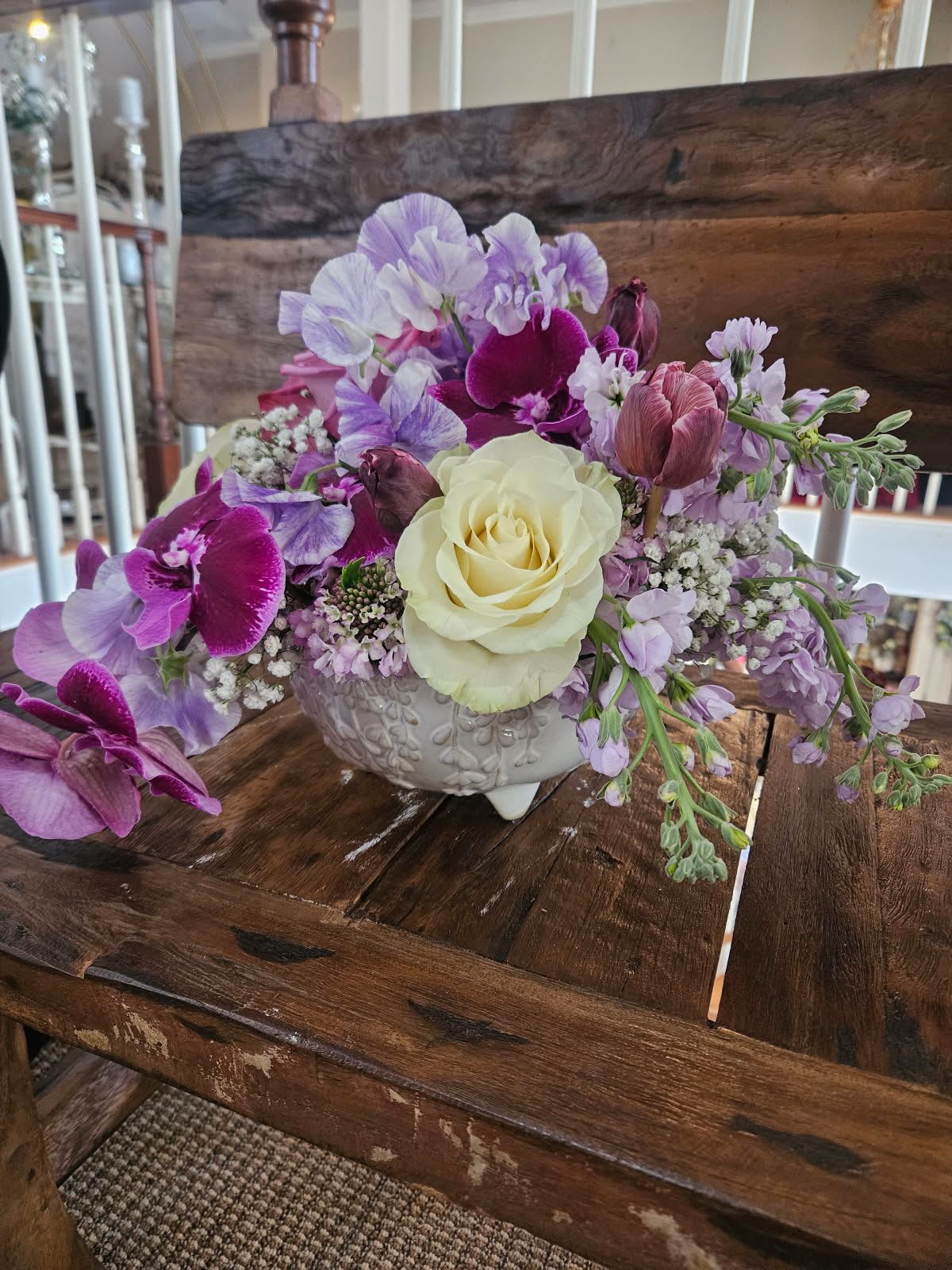 Lush Lavender Passion Bouquet - Lavender and Magenta orchids, white roses, Lavender stock, tulips and fillers arranged in a white ceramic container