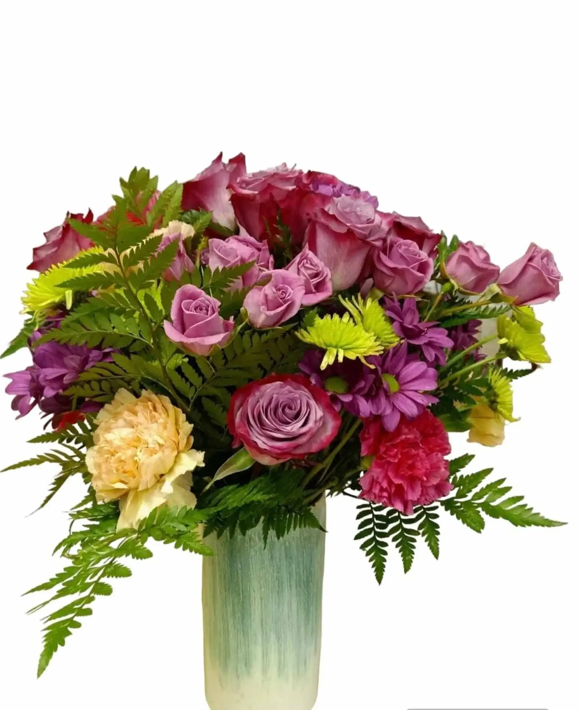 Carnival of Color  - Carnival of Colors&quot; is a vibrant and joyful birthday flower arrangement that bursts with a kaleidoscope of hues and playful energy. This lively composition features the enchanting lavender of roses, the lively spray of pink roses, the classic beauty of white carnations, the fiery hot pink of carnations, the regal purple of margaritas, the whimsical charm of green pom poms, and an assortment of verdant green blooms. With its exuberant colors and festive presence, &quot;Carnival of Colors&quot; is the perfect choice to send your warmest birthday wishes and turn any birthday celebration into a vibrant carnival of joy. Vase may vary and reasonable flower substitutions may be required due to seasonal availability.