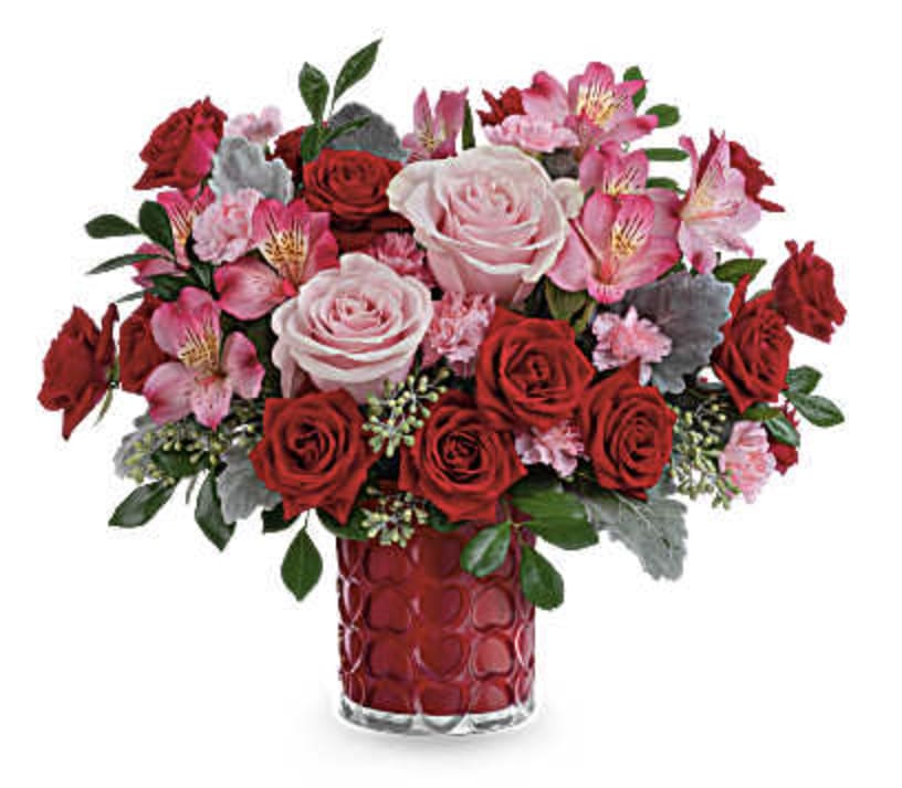 Enchanted Hearts Bouquet - Adorned with a charming heart pattern and gleaming with a pearlescent finish, this delightful glass vase adds an extra touch of magic to their Valentine's Day when filled with a stunning red and pink bouquet.