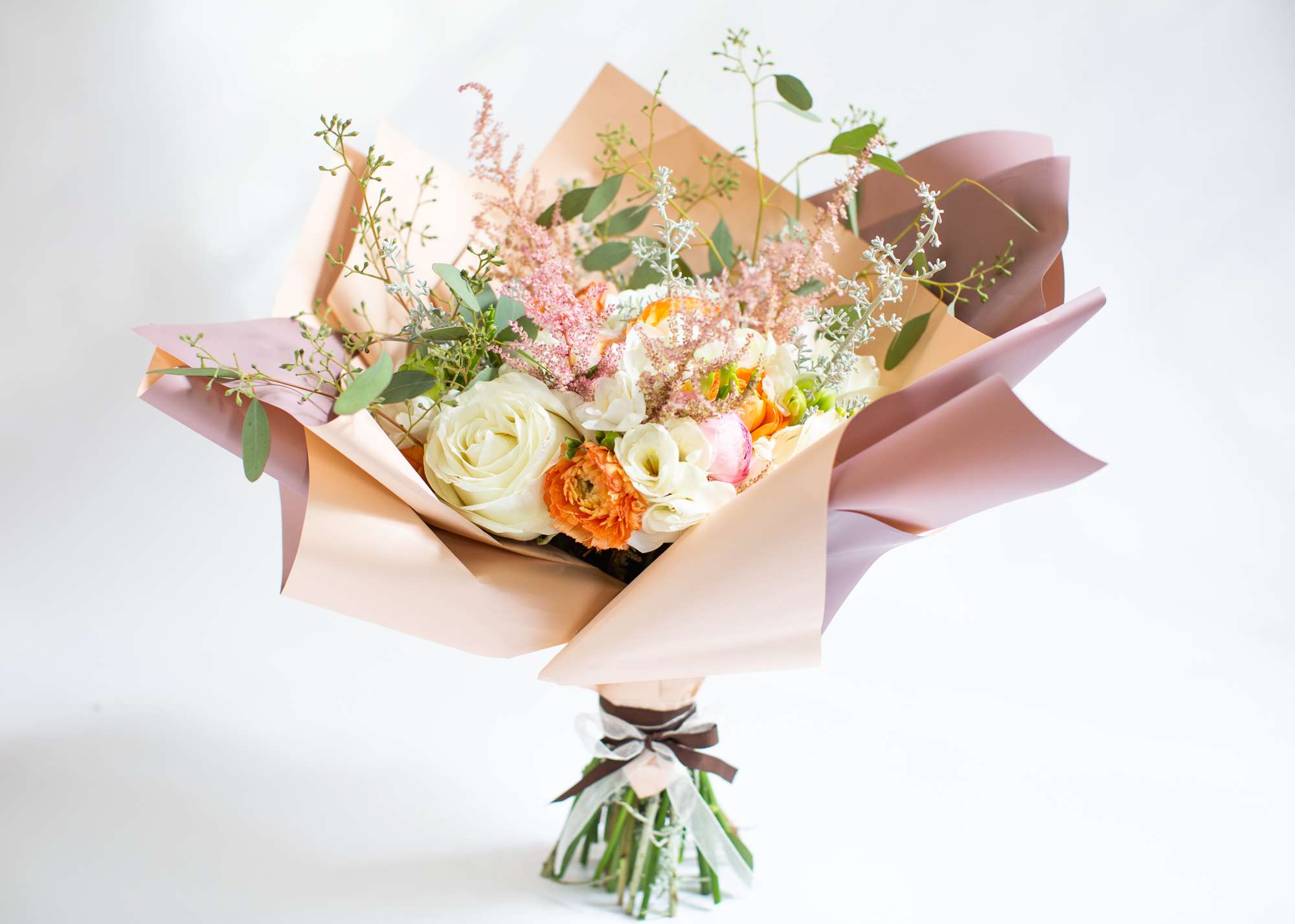Lavish - A hand-tied arrangement includes roses, hydrangeas, freesias, and ranunculus.