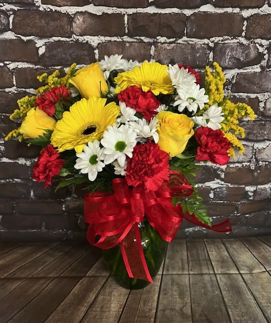 Must Be Love Must Be Love - A beautiful mix of yellow, red and white flowers. Comes in a colored glass vase. Approx. 16" W x 18" H