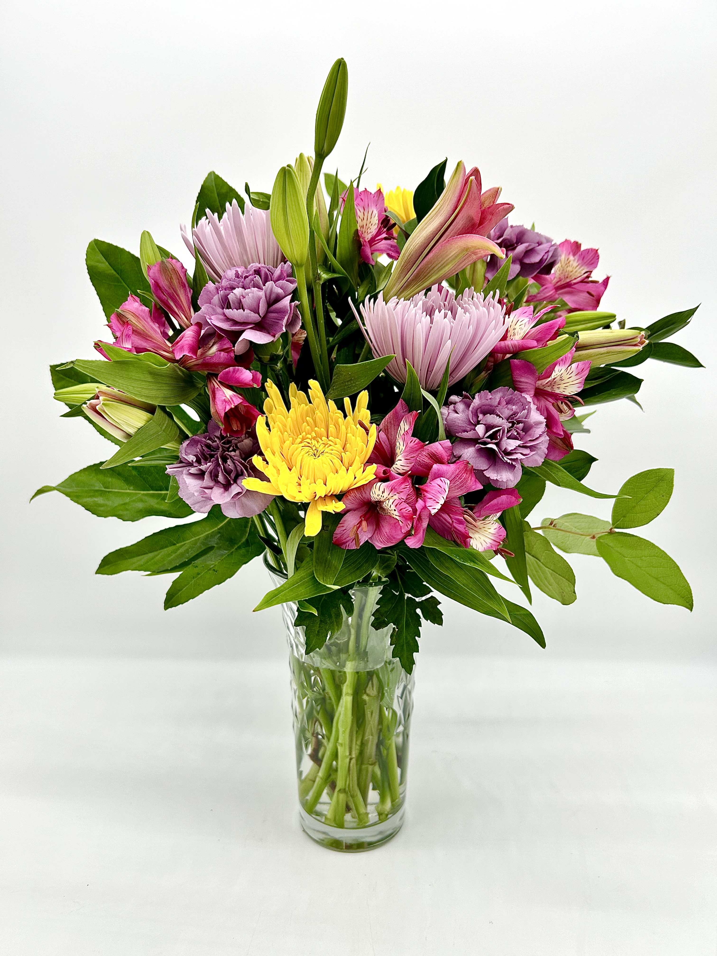Sunset Serenity Sunset Serenity - Sunset Serenity is a lush and soothing floral arrangement that beautifully blends the calming hues of lavender with the cheerful brightness of yellow seasonal blooms. Featuring soft lavender roses, lilies, delicate lavender carnations, and vibrant yellow chrysanthemums or sunflowers, this arrangement evokes a sense of peace and happiness, much like a serene sunset. The combination of cool and warm tones creates a harmonious balance, perfect for adding a touch of tranquility and joy to any setting. Ideal for spring or summer occasions, this bouquet is a thoughtful gift for any celebration, or as a calming centerpiece in your home. All bouquets are arranged by our professional floral design team accented with seasonal filler (i.e. greenery, baby’s breath, etc.) inside an elegant glass vase or gift box. Blooms are hand delivered in person to enhance any celebration or a “just because” surprise. Deliveries are done between 10am - 5pm. If the recipient is not home we will leave the delivery if safe from the elements. We will call or text the recipient and let them know a delivery has been left.