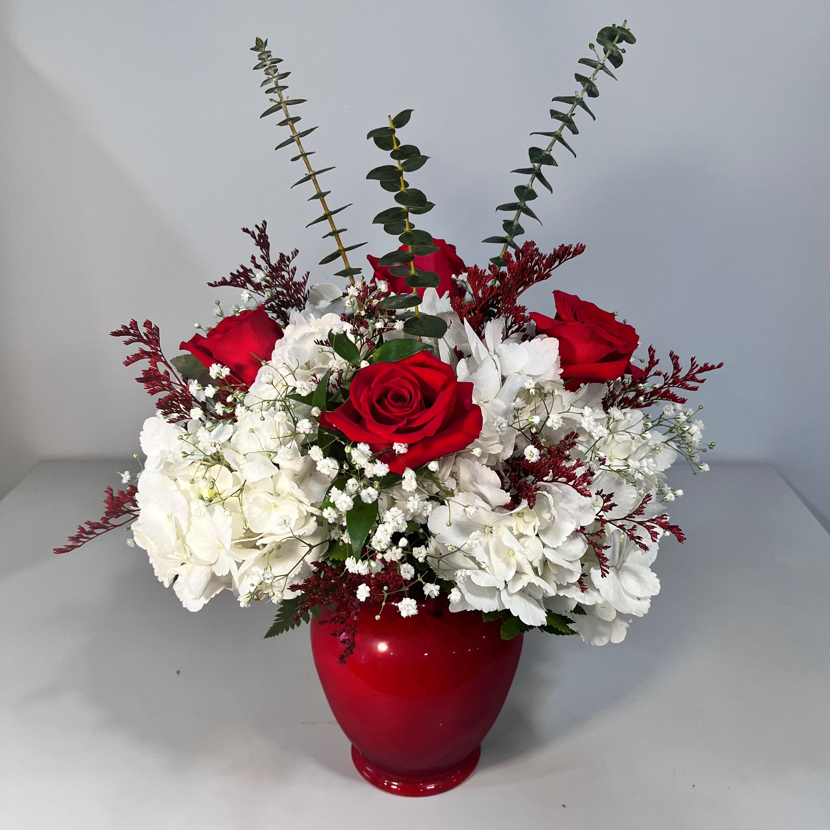 Hydrangea and Rose Vase Arrangement - Hydrangea and Rose Vase Arrangement includes multiple hydrangeas and 4 red roses.