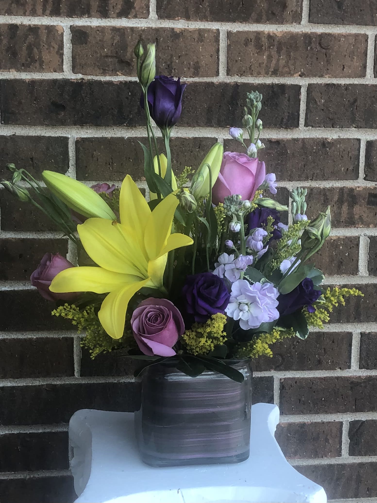 Bounty of Spring Bounty of Spring - Yellow lily, lavender roses and stock, lisianthus and solidago in a vase.
