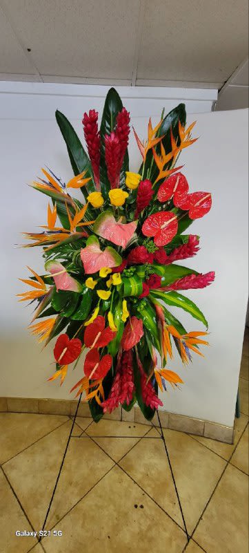 Tropical Farewell - A Vibrant Tribute of Love &amp; Remembrance  Honor the memory of your loved one with Tropical Farewell, an exquisite funeral spray designed to convey deep respect, love, and a celebration of life. This grand arrangement, filled with vibrant tropical blooms, serves as a heartfelt farewell while symbolizing the beauty of cherished memories.  What's Included?   Red Ginger – Representing strength and admiration, these striking blooms bring warmth and depth to the arrangement.  Bird of Paradise – A symbol of peace and paradise, reflecting the journey to eternal rest.  Red Anthurium – Embodying deep love and appreciation, these exotic flowers add elegance and meaning.  Heart-Shaped Pink Anthurium – A tribute of love, showcasing softness, care, and devotion.  Yellow Calla Lilies – Representing gratitude and rebirth, they add a touch of serenity.  Yellow Roses – A symbol of friendship and remembrance, expressing warm and fond memories.  Heliconia &amp; Tropical Leaves – Lush greenery enhances the beauty and grandeur of this unique spray.  Price: $450   Perfect for: Funeral services, memorials, or as a loving gesture to honor a departed soul.
