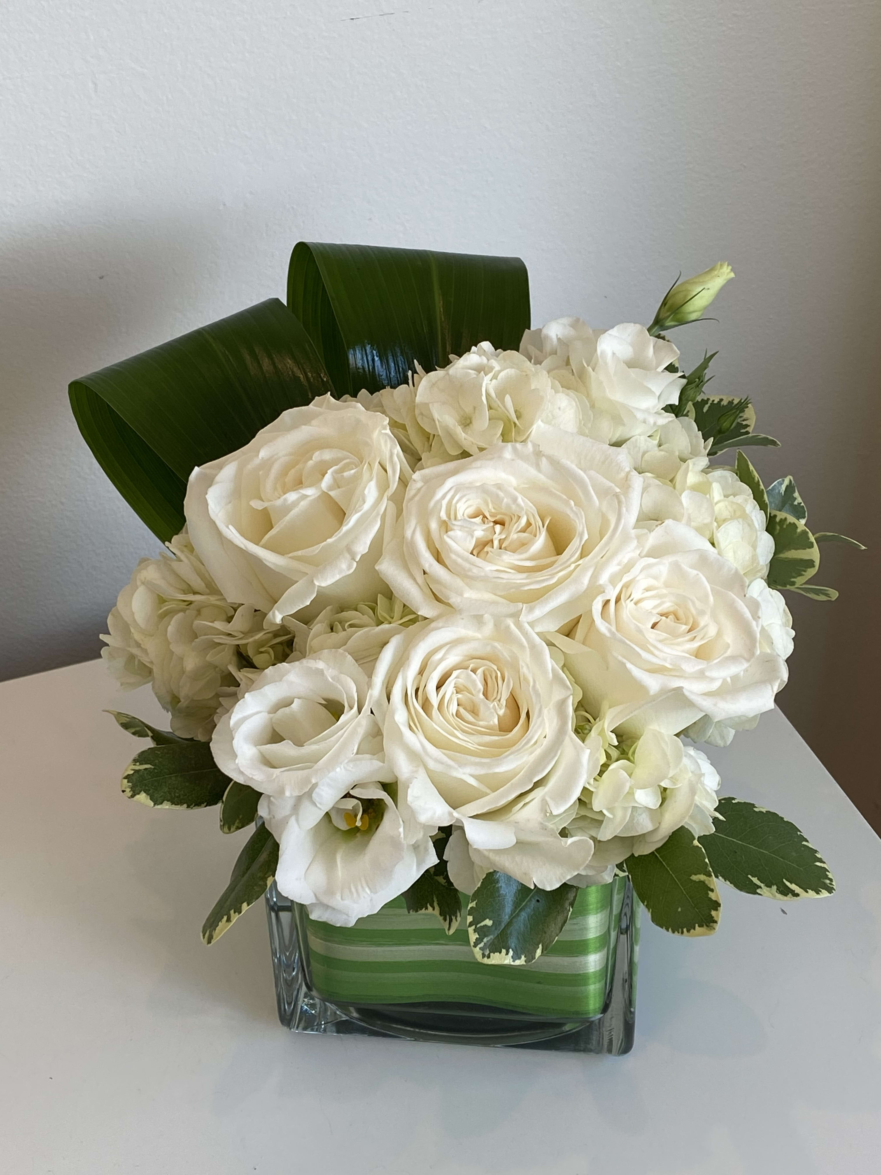 REG-28 REG-28 - White Hydrangea, Roses & Lisianthus in Square Glass Vase with Assorted Foliage.