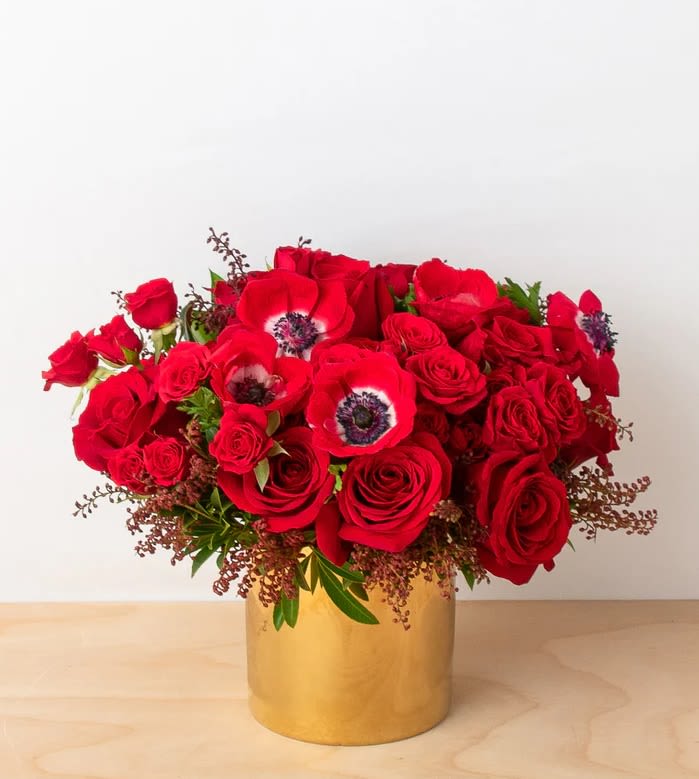 Passion in Red - Celebrate love in its most luxurious and passionate form with &quot;Passion Éternelle&quot;, a breathtaking Valentine's Day floral arrangement that exudes romance and sophistication. This opulent bouquet features premium red roses, symbolizing deep love and devotion, beautifully intertwined with striking red anemones, known for their captivating black centers, adding depth and contrast. Accented with delicate seasonal greenery and textured foliage, this lush arrangement is designed to leave a lasting impression.  Nestled in a chic, golden metallic vase, this floral masterpiece adds a touch of elegance and timeless beauty to any space. Whether you're surprising your special someone or indulging in a self-love gesture, &quot;Passion Éternelle&quot; is the perfect expression of affection and grandeur.   Ideal for: Valentine's Day, Romantic Gestures, Anniversaries, Luxury Floral Gifts  Dimensions: Approx. 14&quot; high x 16&quot; wide  #Valentine's Day Flowers, # Luxury Red Roses,  #Romantic Floral Arrangement,  #Elegant Flower Bouquet,  #Red Anemone Arrangement,  #Gold Vase Floral Design