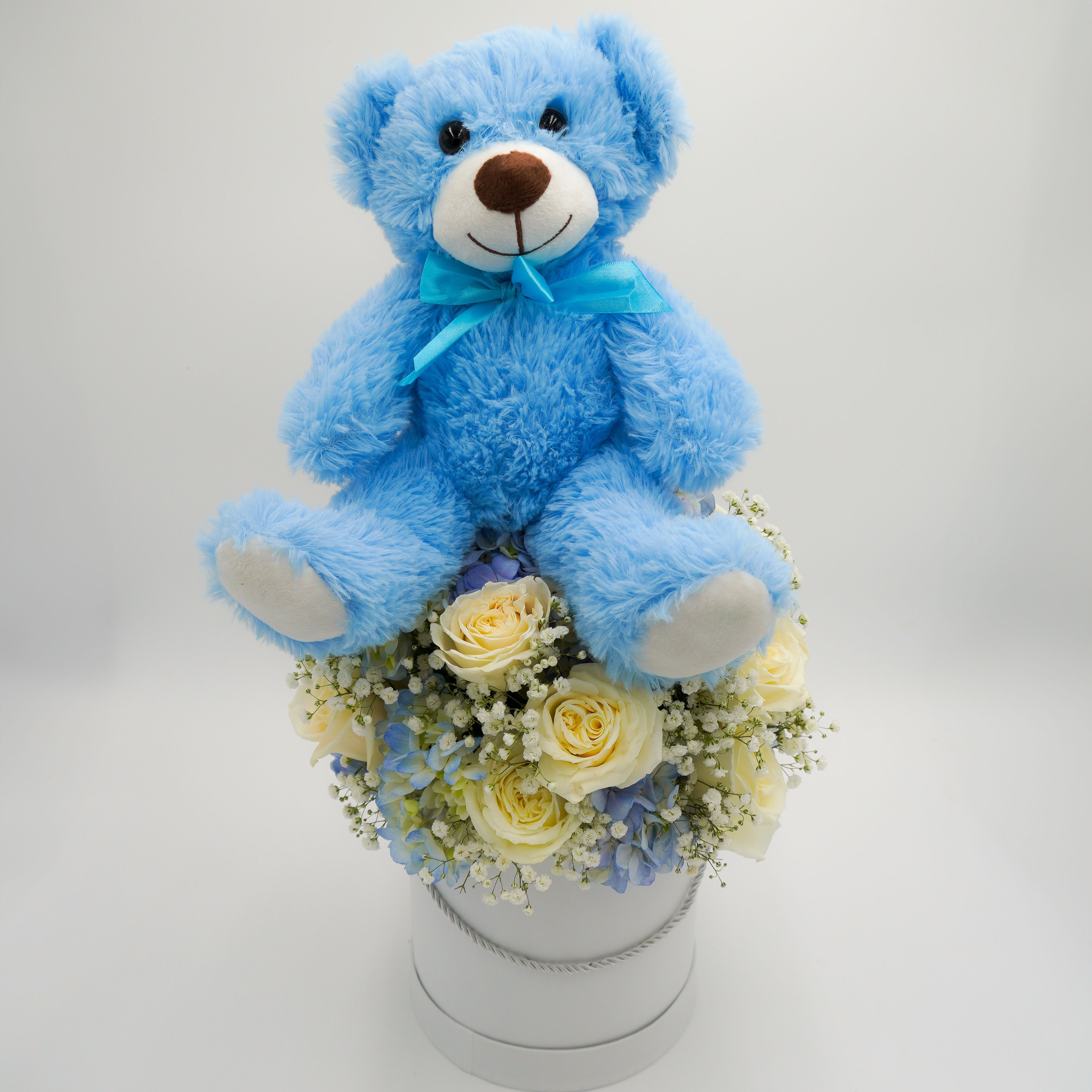 It's a BOY! by Atlanta's Finest Flowers - Includes blue hydrangea, white roses, baby breath, and blue teddy bear on top  *Box Material*: Size 7x7
