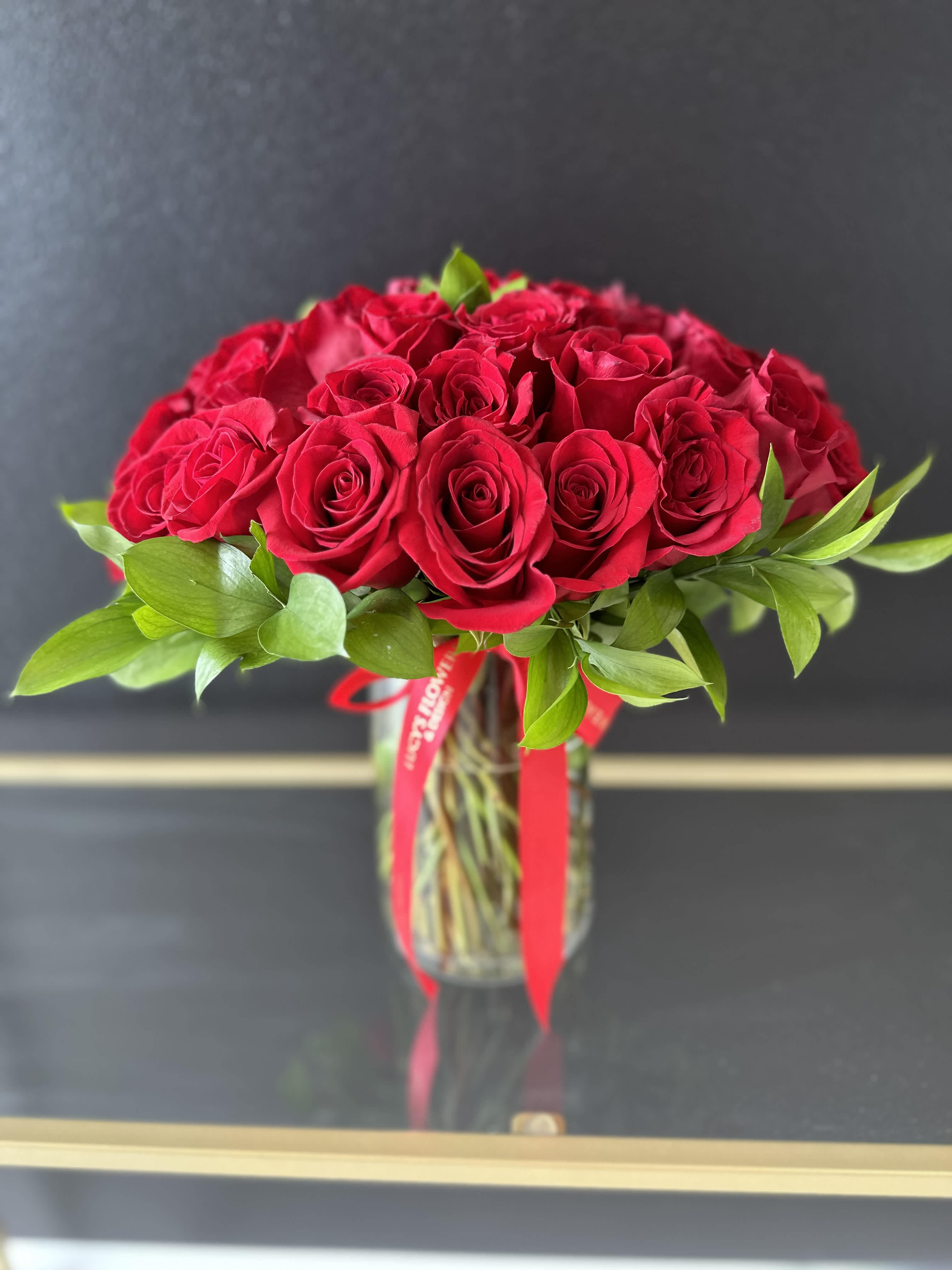 “36 Roses of Love” -  A timeless symbol of love, this stunning arrangement features 36 red roses delicately arranged in a sleek vase. With its bold, vibrant color and luxurious feel, this bouquet captures the essence of romance and devotion, making it the perfect gesture to express deep affection. Three Dozen Red Roses is the perfect gift for Valentine's Day, an Anniversary, or when anytime you're feeling romantic.   Arrangement Includes: -Fresh Cut 36 Red Roses &amp; Greenery  -Glass Vase  -Custom Greeting Card -Care Instructions 