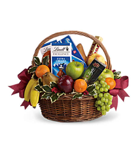 Fruits and Sweets Christmas Basket - A bountiful Christmas gift basket that will please the health-nut and chocoholic alike! A delicious assortment of gourmet chocolates and fresh fruit are presented in a handled basket and decorated with sprigs of festive holly. It's a mouth-watering choice for a corporate holiday gift, get well gift or thank-you gift! 4 apples, 2 bananas, 2 brown pears, 2 oranges, 3 tangerines and one bunch of green grapes are mixed with 4 gourmet chocolate bars and a box of cookies in a large handled basket. Variegated holly and red metallic ribbon add a seasonal spin. Orientation: N/A