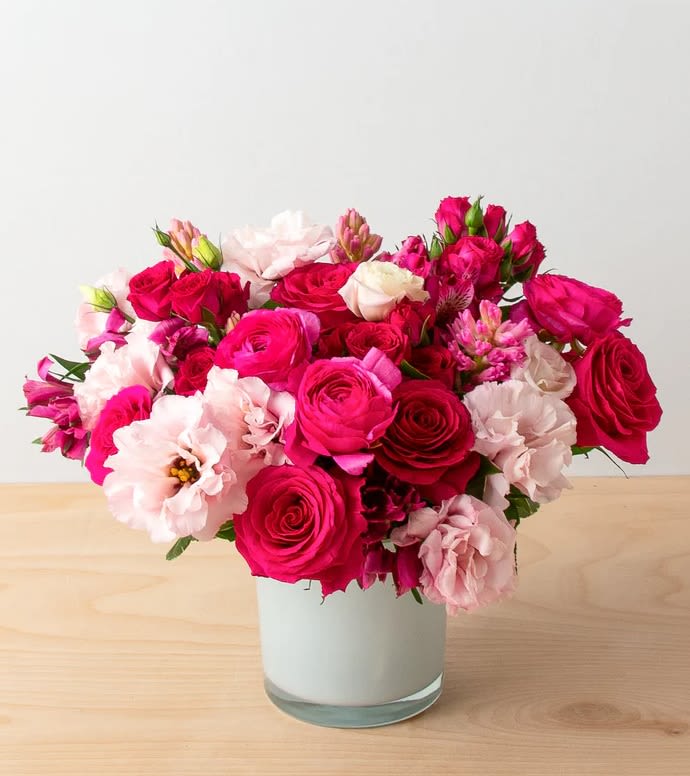 Éclat Romantique - Ignite the fire of romance this Valentine’s Day with &quot;Éclat Romantique&quot;, a vibrant and luxurious floral arrangement designed to captivate and enchant. This bold and radiant bouquet showcases lush hot pink garden roses, delicate spray roses, vibrant ranunculus, and soft lisianthus, masterfully arranged in a modern glass vase to create a striking statement of elegance and desire.  The rich and dynamic shades of fuchsia, deep pink, and soft blush represent passion, romance, and admiration, making this bouquet the perfect choice for those who love bold expressions of affection. The soft petals and lush textures blend harmoniously, while the fresh greenery adds depth and vibrancy, ensuring a luxurious and unforgettable floral experience.  With its intense color palette and refined design, &quot;Éclat Romantique&quot; is the ultimate Valentine’s Day gift, guaranteed to make hearts race and emotions soar.  Dimensions: Approx. 13&quot; high x 13&quot; wide  #Luxury Vibrant Floral Arrangement #Bold Pink and Red Roses #High-End Romantic Flower Gift #Elegant Ranunculus and Lisianthus Bouquet #Sophisticated Valentine's Floral Design