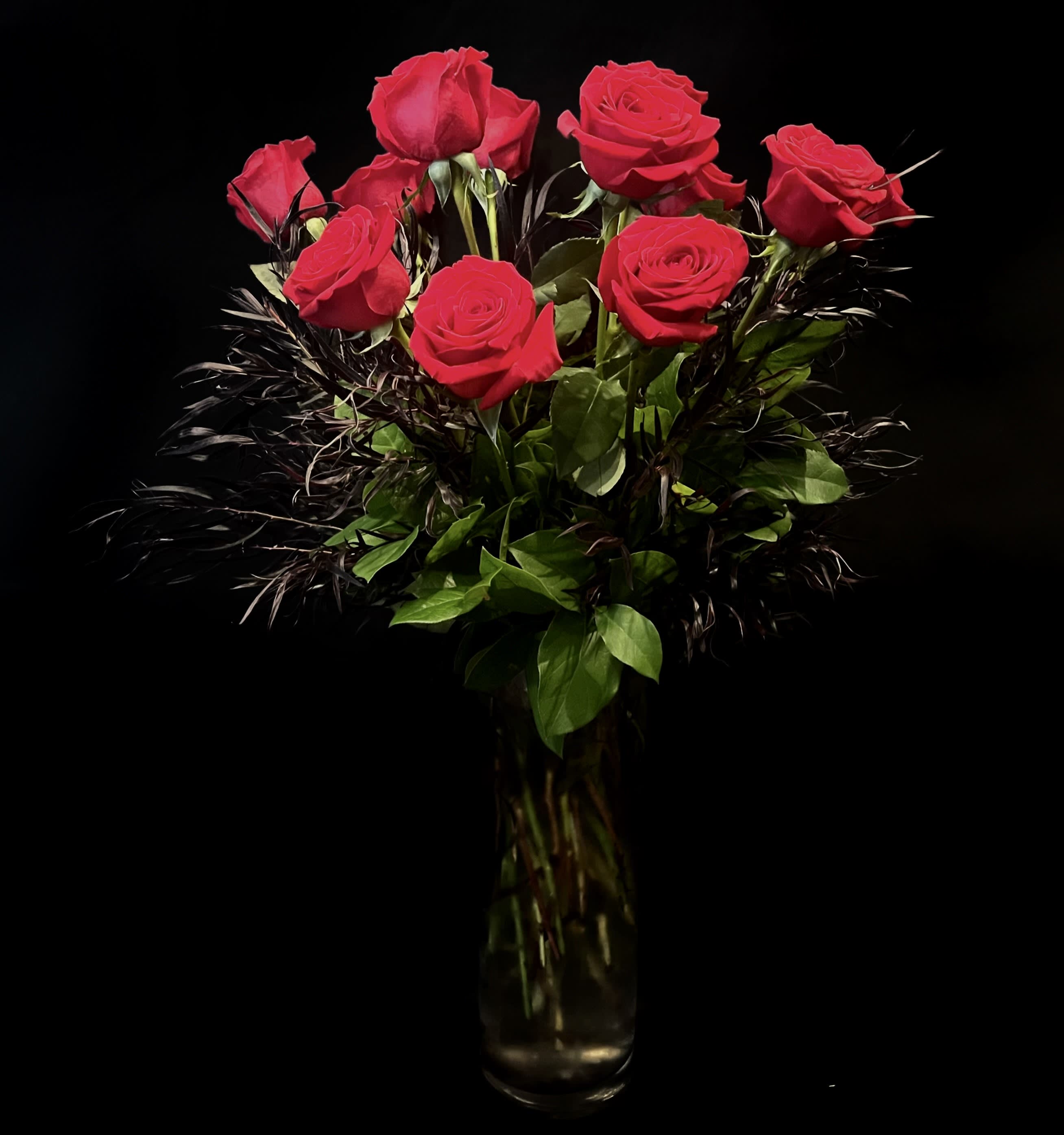 Pure Valentine 1645 - An elegant arrangement of red roses, mixed with feathery burgundy agonis and greens suspended in a tall glass vase