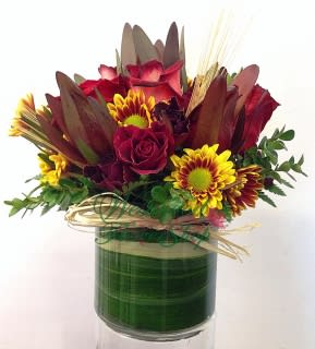 Bold and Beautiful  - Something bold and beautiful for her! Rekindle the romance by sending this bouquet full of roses, safari, and daisy arranged centerpiece style in a keepsake cylinder glass vase.  Approximately 9” D