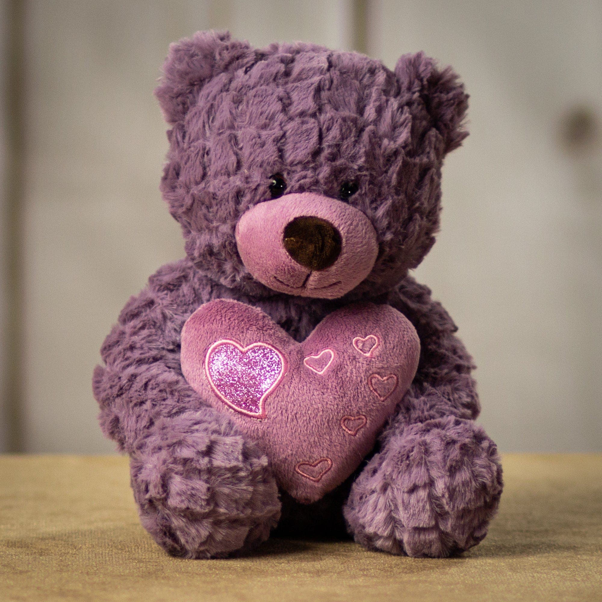 Violet Bear Violet Bear - These pastel-colored teddy bears sport a fluffy texture of fur along with a smooth heart that complements their Valentine vibe. The heart is accented with smaller hearts, some of which sparkle and shine. When you get a set of six, you get three of each color: pink rose and purple violet. Size - 10 inches while sitting, from head to bottom Feel - Soft and cuddly, stuffed with hypoallergenic fiber fill