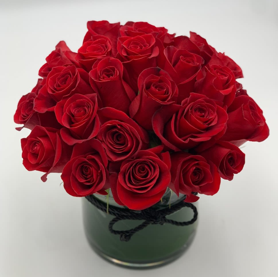 The Flower of Love The Flower of Love - a beautifully designed round bouquet of deep red roses in crystal clear cylinder vase to make the recipients eyes shimmer as they receive this classy yet gorgeous arrangement.