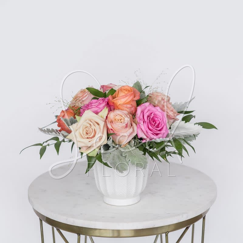 A Pretty Dozen Roses - Classic roses get a summer makeover in bold summer hues. Featuring: Roses, Dusty Miller, &amp; Ruscus Italian in a 4.75&quot; white ceramic vase.  STANDARD: 1 Dozen Assorted Color Roses DELUXE: 1 1/2 Dozen Assorted Color Roses 