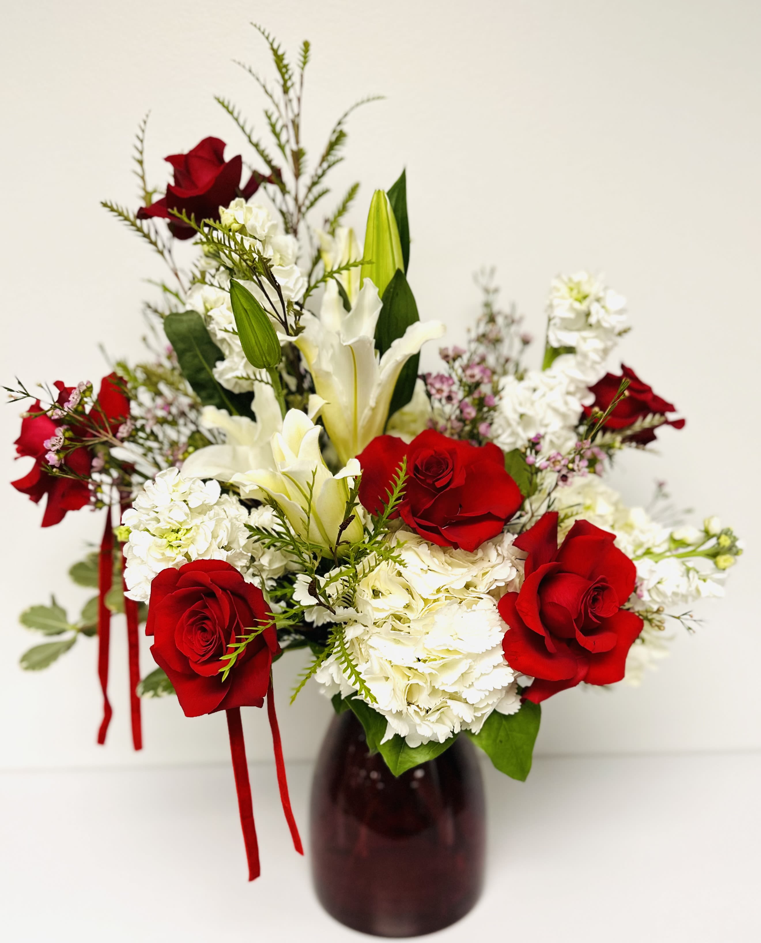 luxurious velvety red roses - Nothing says LOVE like luxurious velvety red roses  This Valentine’s, go beyond words and surprise them with a bouquet that speaks straight to the heart! Tall red glass vase filled with white Hydrangeas, white stock, red roses, lilies, with premium greenery and wax flower.  