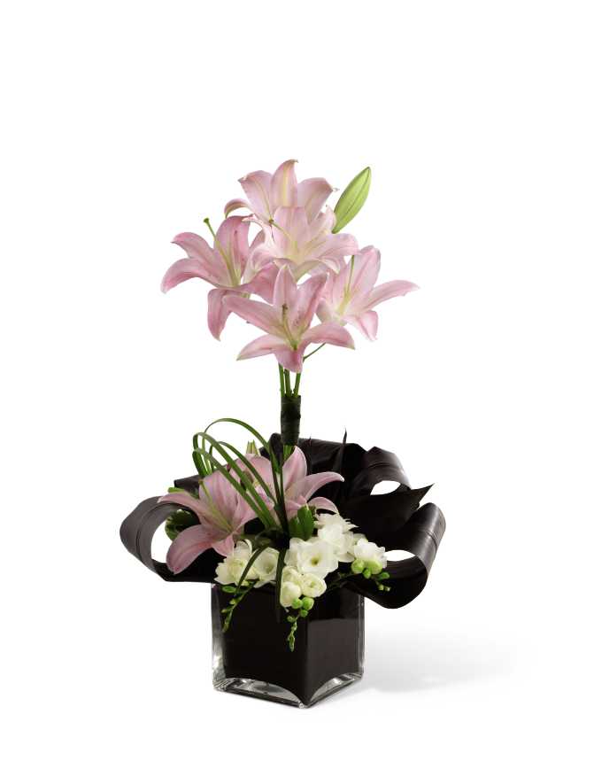 Never-Ending Love Arrangement Never-Ending Love Arrangement - Never-Ending Love Arrangement is a sweet symbol of a love that defies all odds. Pale pink lilies are arranged amongst white stock, ti leaves, lily grass and pittosporum greens in a clear glass cube to display your adoration and affection for the dearly departed.