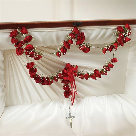 Large Rosary with Red Spray Roses - Express your faith and love with this inspiring and beautiful floral tribute arrangement. Features one dozen attractive red spray roses draped around a large string of rosary beads Accented by Babys Breath and finished with a satin ribbon Traditionally sent by children or grandchildren directly to the funeral home Our florists use only the freshest flowers available so varieties and colors may vary Measures approximately 40&quot;W 
