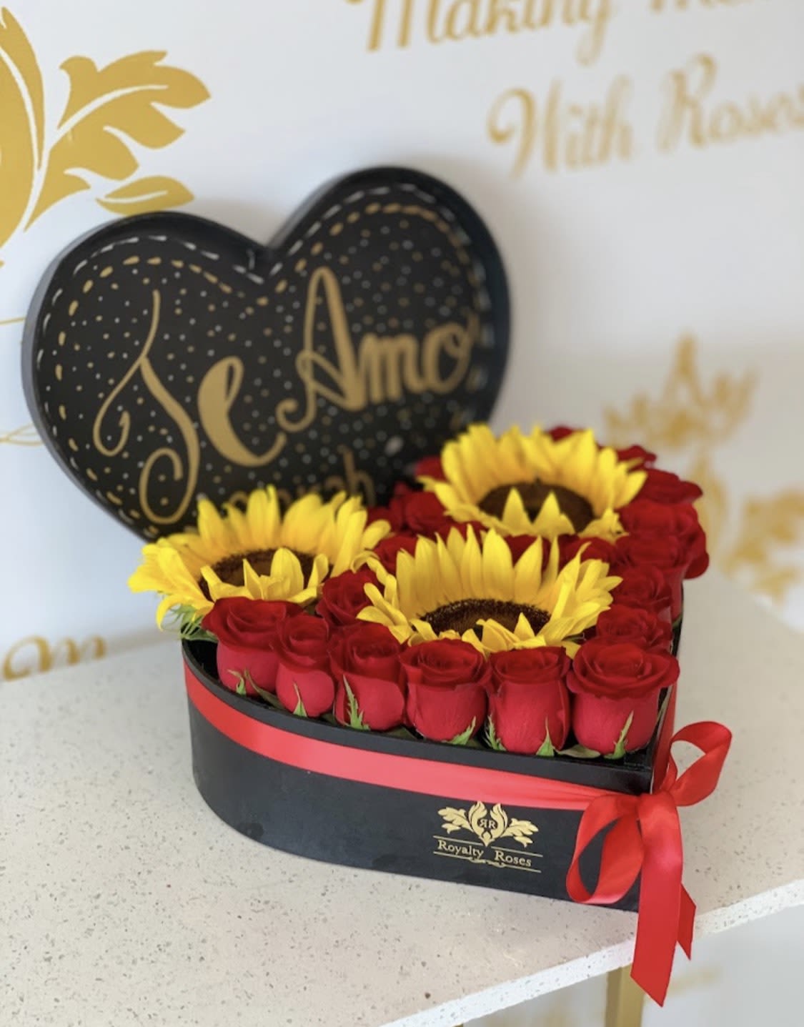 HEART #2 RED ROSES AND 3 SUNFLOWERS HEART #2 RED ROSES AND 3 SUNFLOWERS - Bloom with Love: Royalty Heart #2 - Where Passion Meets Petals! Unleash the power of emotion with our signature Heart #2 arrangement - a breathtaking symphony of 3 radiant Sunflowers embraced by elegant Roses. This isn't just a bouquet; it's a heartfelt message that speaks volumes without saying a word. Capture the Moment: -Sunflower smiles that brighten any day -Roses that whisper romance -A heart-shaped design that says "I care" Perfect for: -Romantic gestures -Special celebrations -Expressing deep emotions Crafted with Love: Where Every Petal Tells a Story