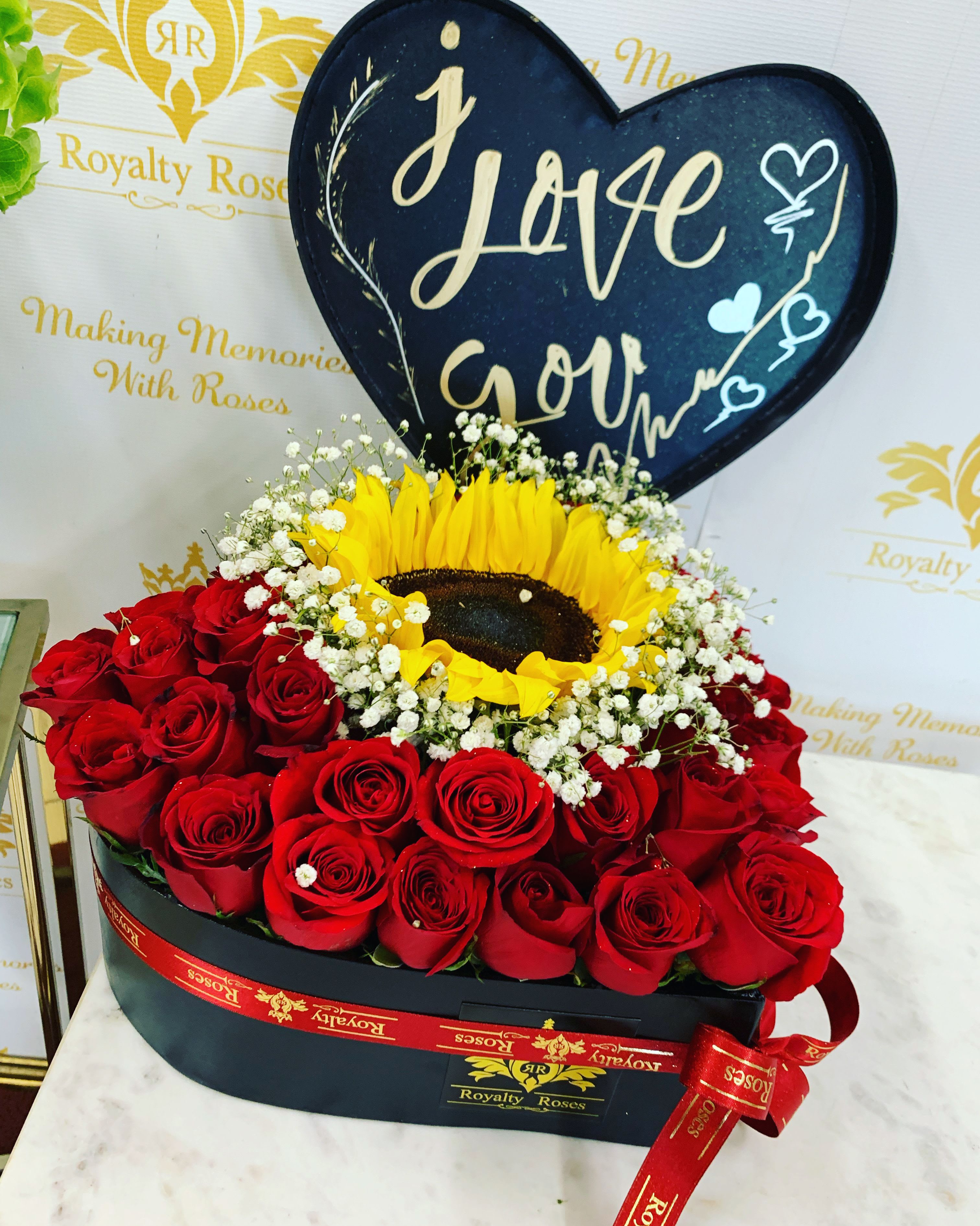 HEART #2 RED ROSES AND A SUNFLOWER -  LOVE BLOOMS HERE: HEART OF PASSION COLLECTION   Introducing Our Royalty Roses Signature Heart Rose Box Where Romance Meets Perfection! What Makes This Extraordinary:  Luxurious Heart-Shaped Box  Around 36 Premium Red Roses  ONE Stunning Sunflower Centerpiece  Delicate Baby's Breath Accent The Ultimate LOVE Statement Handcrafted with Precision Instagram-Worthy Design Guaranteed to Melt Hearts  VALENTINE'S SPECIAL PRICING