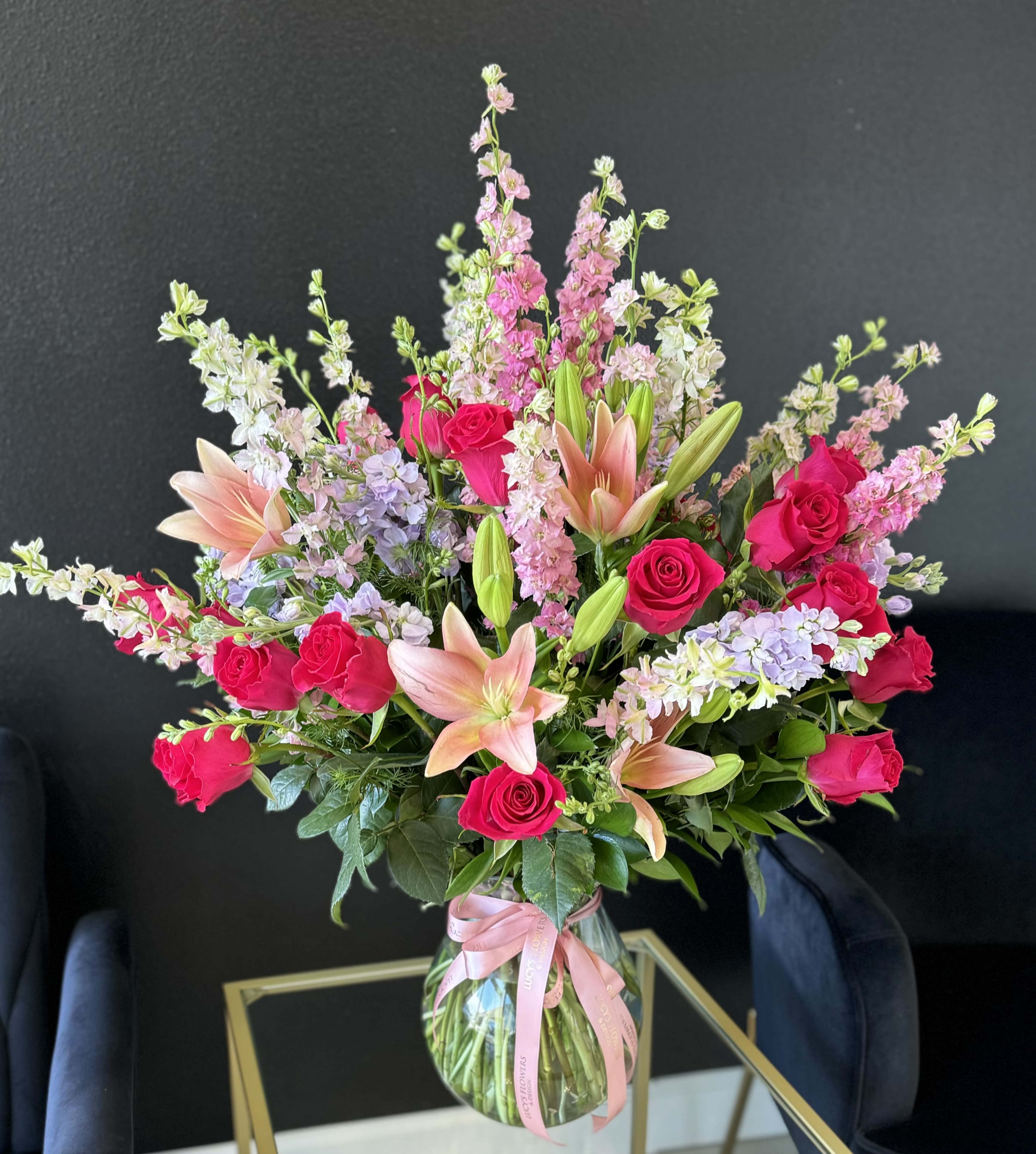 Loving Roses and Lilies Loving Roses and Lilies - Pink Asiatic lilies, pink roses, stock and other mixture of flowers, create floral magnificence in a clear large vase with a signatue ribbon. This exquisite bouquet will definitely bring a smile to your recipient's day. Arrangement Details: -Fresh Cut Roses, Lilies, Stocks and Ruscus Leaves -Tall Glass Vase -Custom Greeting Card -Care Instructions