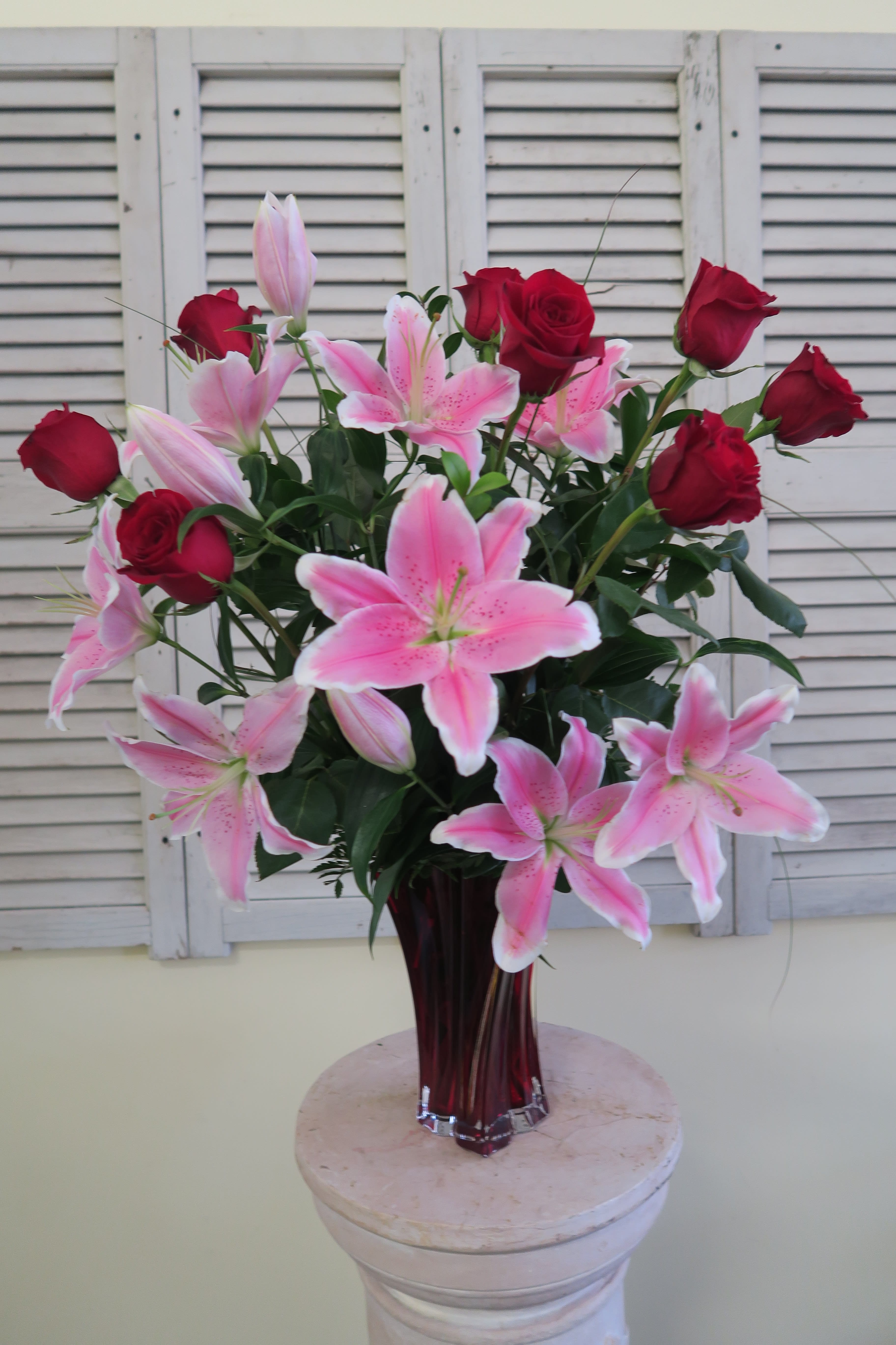 You Make My Heart Sing You Make My Heart Sing - Long Stem red roses, pink Sorbone lilies embellished with various greens. Presented in twisted red vase.