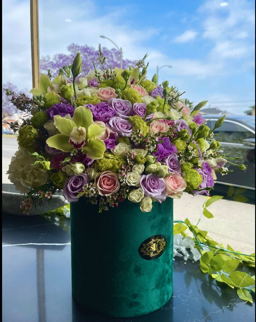 Emerald  - Brighten any space with our Elegant Flower Box Arrangement! Bursting with vibrant blooms, this stunning display combines seasonal favorites with lush greenery.   Housed in a chic, reusable container, it makes a perfect centerpiece for any occasion be it a gift or a treat for yourself. Elevate your decor with this captivating arrangement that brings joy and sophistication to your home or office. Order yours today and let the beauty of flowers inspire you
