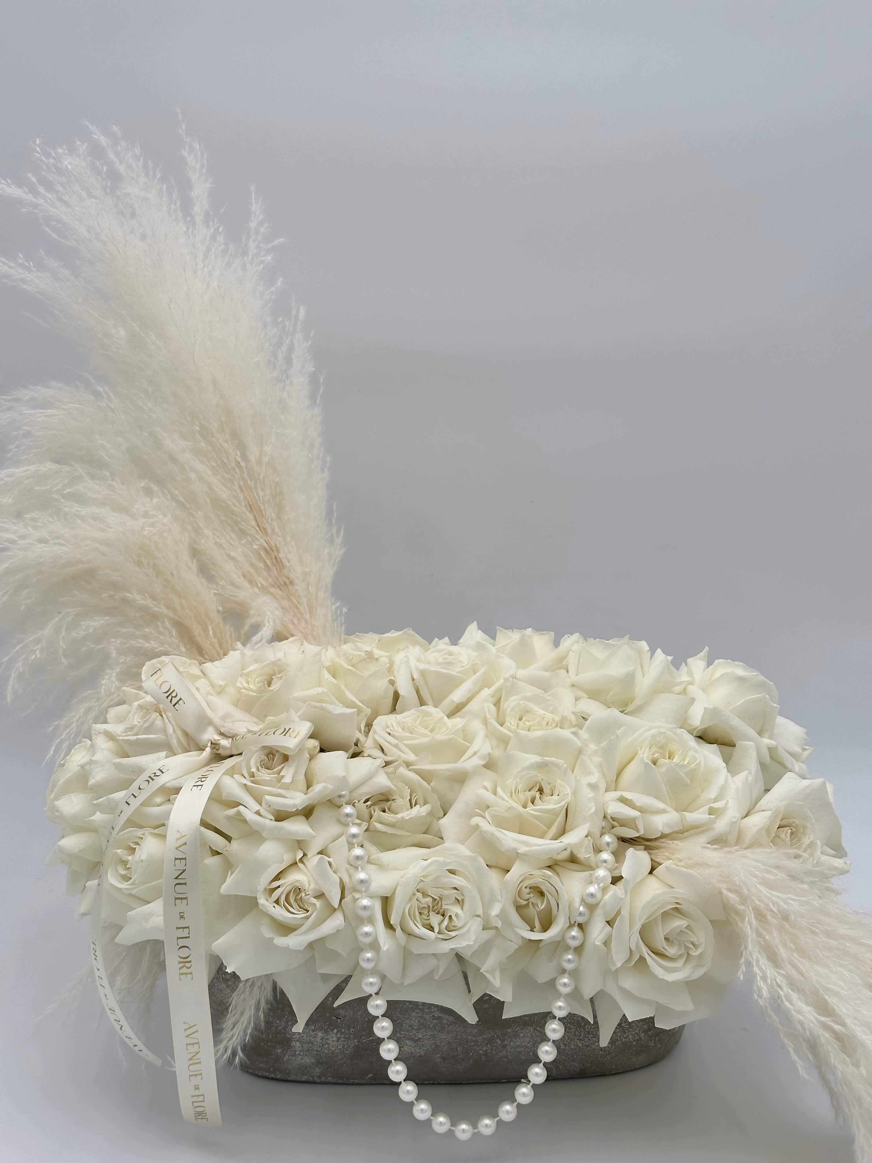 Ice Queen Ice Queen - Introducing "Ice Queen," a captivating arrangement that effortlessly marries the ethereal beauty of white roses with the timeless elegance of delicate pearls. This floral masterpiece is a visual symphony, an expression of pure sophistication.