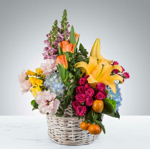 April Showers by BloomNation™ - Featuring lilies, tulips, clementines, spray roses, lisianthus, daffodils, ivy and more in a classic white wicker basket, April Showers by BloomNation™ is the ultimate spring arrangement. Short of a pollen allergy and a bunny, this is as close to gifting a season you can get. Perfect as an Easter or Passover gift, this arrangement will be sure to impress.   APPROXIMATE DIMENSIONS 17" W X 24" H