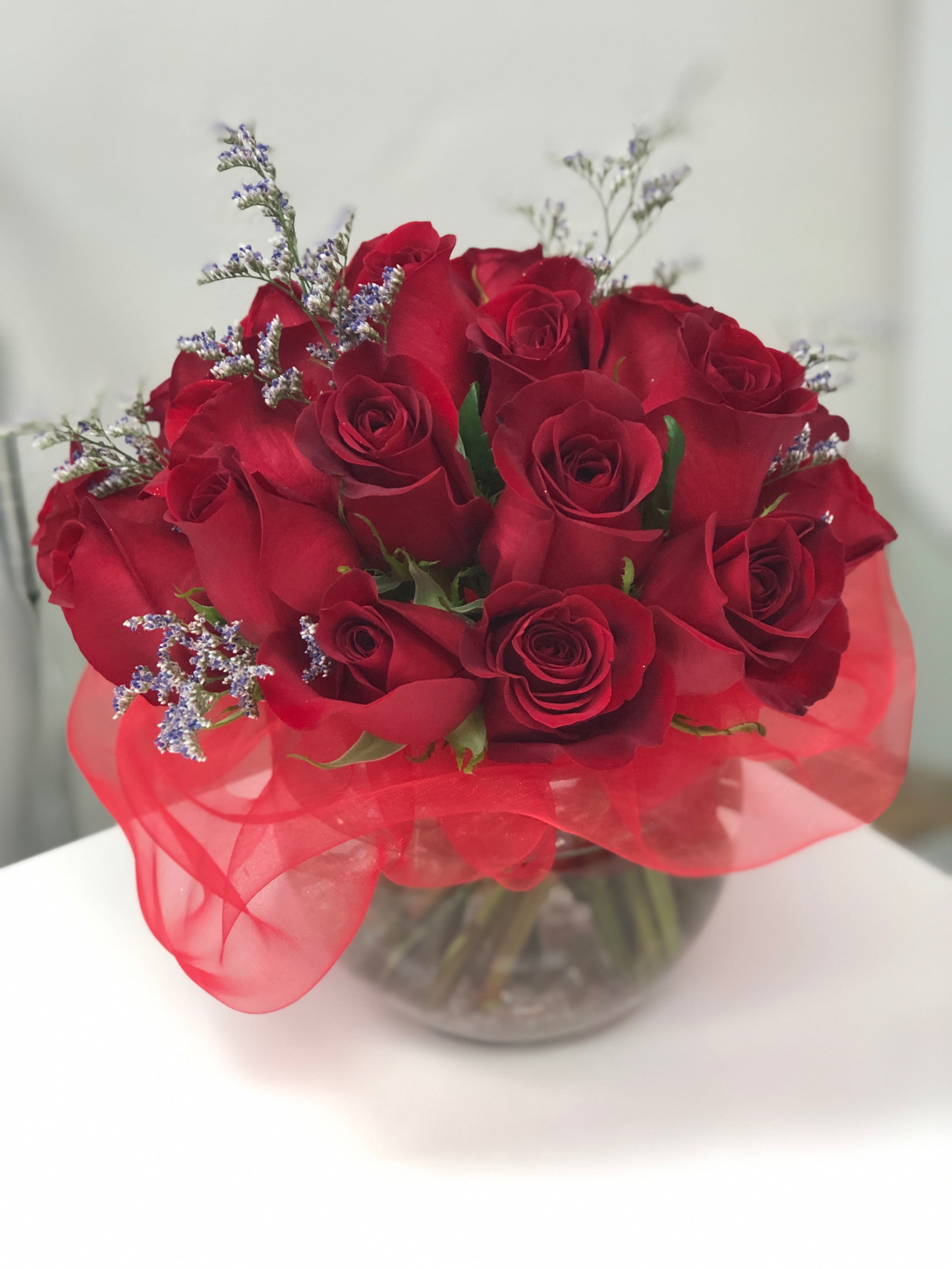 Double Dozen Round Red - 2 dozen red roses with a touch of accented flowers in a medium fishbowl or cylinder