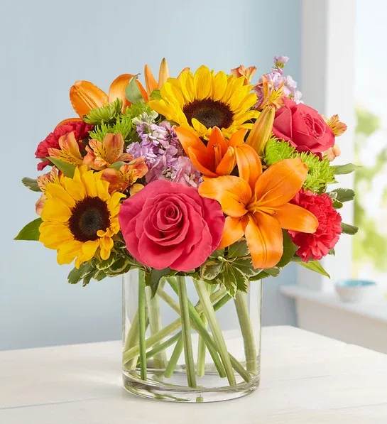 FLORAL EMBRACE - Like a warm embrace, our vibrant flower bouquet delivers your sentiments to someone special. A rich gathering of yellow and orange blooms, with pops of bright pink and purple, it's more than a gift…it's a way to express how you feel inside.