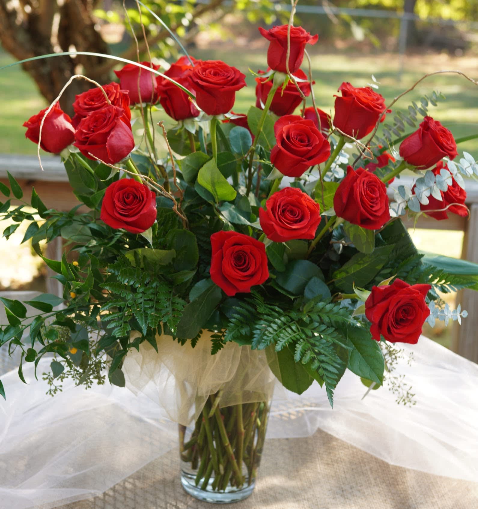 Two Dozen Red Roses with Mixed Greens - Our Two-Dozen Red Roses is absolutely breathtaking!  Our roses are fresh, long lasting and a perfect symbol of true love and romance!  This two dozen is artfully arranged in a heavy, clear vase surrounded by seasonal, assorted mixed greens.  Fragrant eucalyptus, bear grass and curly willow bring a modern touch to this classic beauty.  APPROXIMATE DIMENSIONS - 28&quot; in  x  28&quot; in  SUBSTITUTION POLICY - In dealing with fresh product, sometimes it may become necessary to replace one particular flower for another one.  Rest-assured, if we make a substitute, it will be of equal or greater value!  Thanks for your understanding, S &amp; K