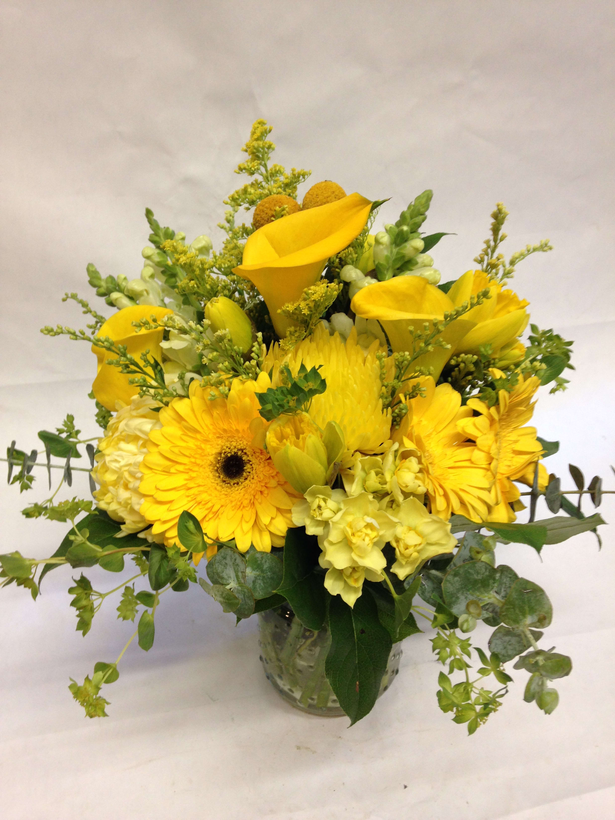 Bright Lemon Spring. Bright Lemon Spring. - Gives someone a burst of brightness! This powerful yellow arrangement features yellow callas, spider mums, gerbera daisies, billy balls and seasonal greenery. (Some flowers may be subject to change depending on the season. We will contact you with available flower substitutions; please contact us with specific questions if you are concerned with flower availability, thanks!) Featured Arrangement: $125.00.