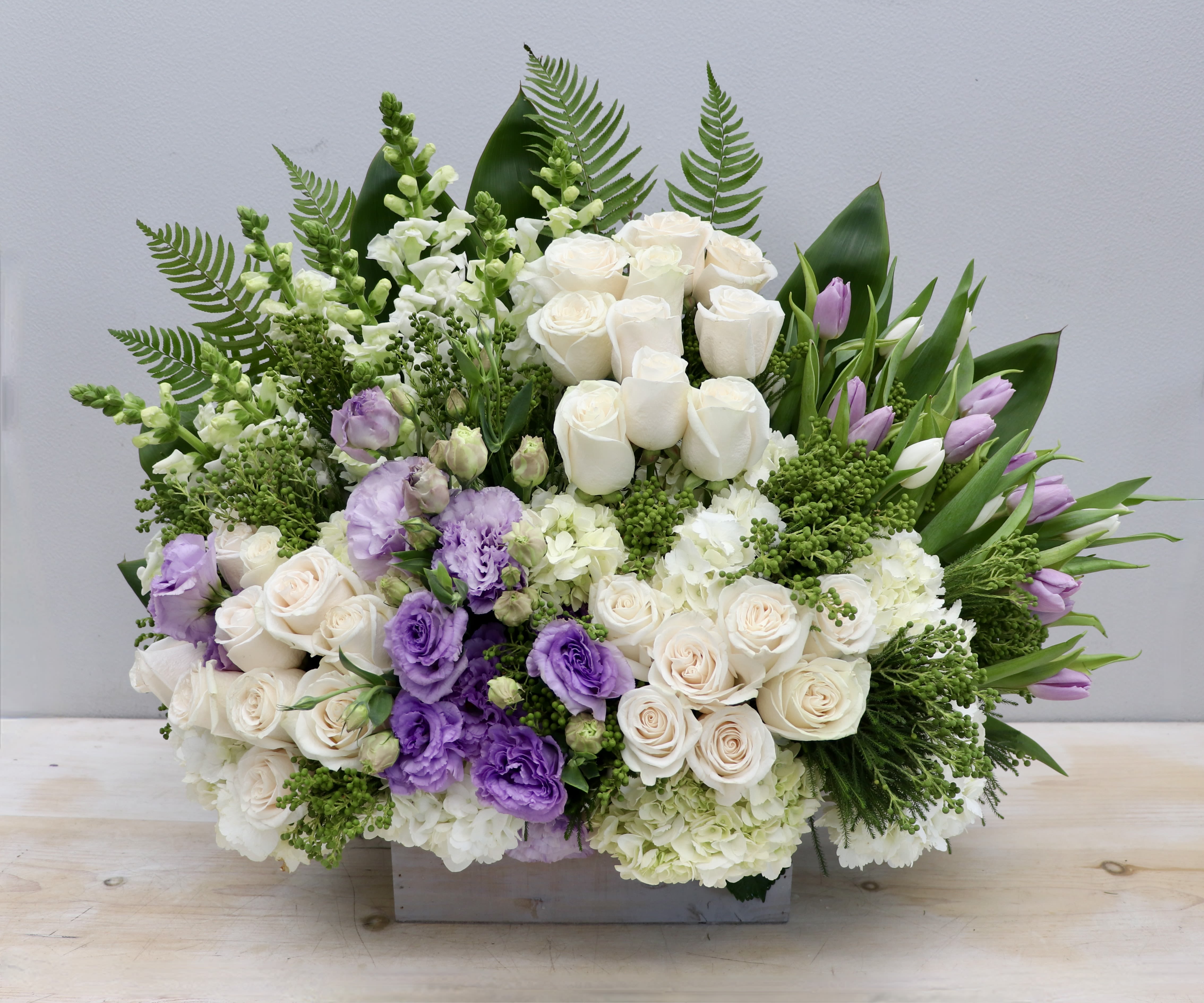 Lavender Remembrance Lavender Remembrance - This sympathy box combines beautiful white roses, snapdragons, and hydrangea with lavender lisianthus and tulips. This arrangement is a lovely way to honor a loved one. The standard size is approximately 30'' tall and 30'' wide.