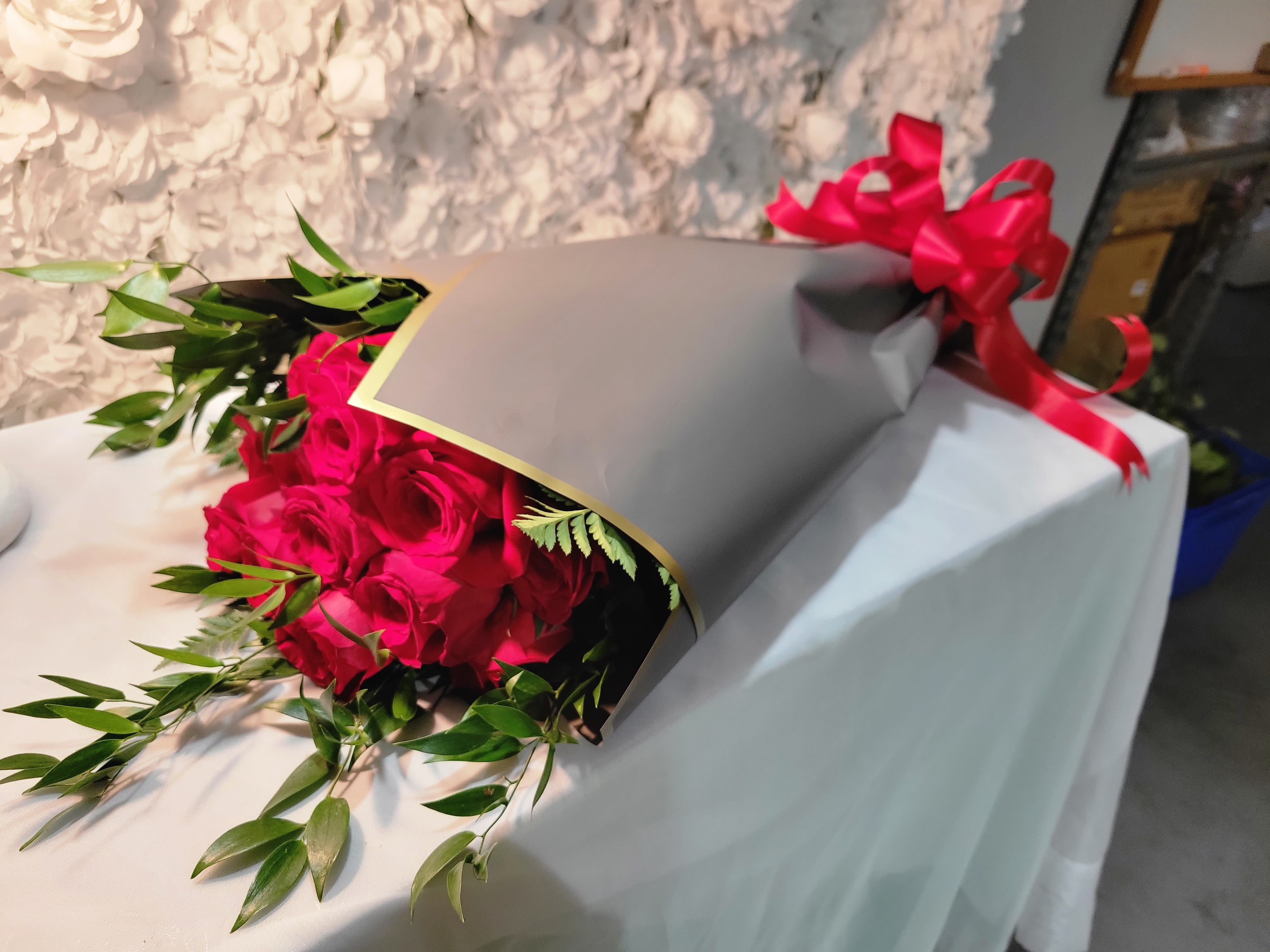 Wrapped with Love   By Cut 1 Floral Design - &quot;Wrapped with Love&quot; is an elegant presentation featuring a dozen rich, red roses, beautifully wrapped to highlight their timeless beauty and elegance.  The roses are arranged with care, showcasing their stunning petals and vibrant color, making them the perfect expression of love and admiration.  The thoughtful presentation, measuring approximately 30 to 32 inches in length, creates a striking visual impact, ideal for any special occasion or as a meaningful gesture of affection.  Wrapped with sophistication, this bouquet is sure to leave a lasting impression.