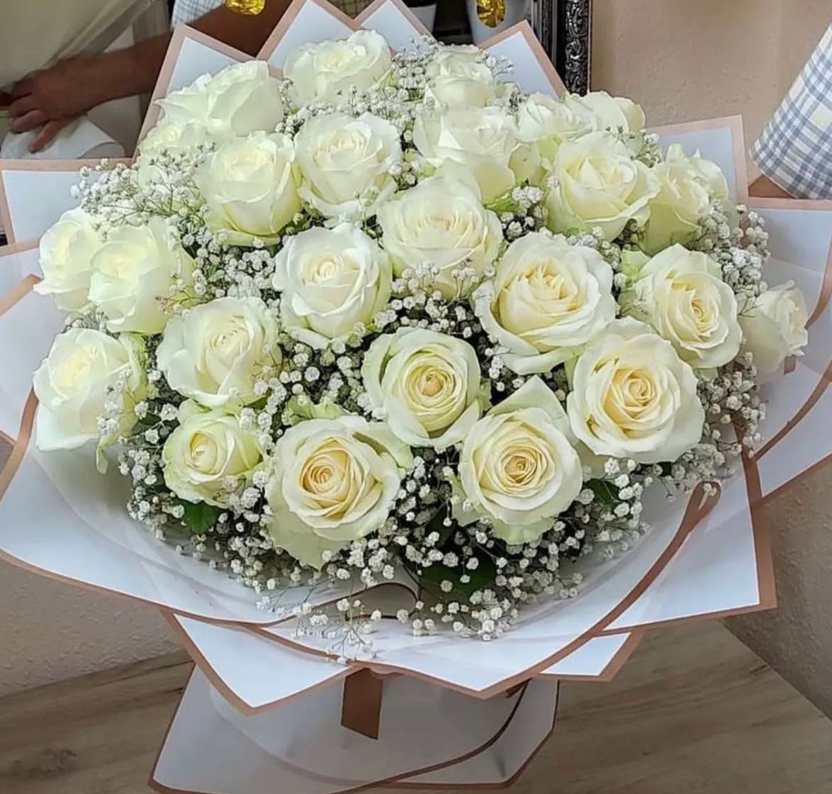 All White Rose Bouquet - Roses wrapped in waterproof paper with babies breath. 