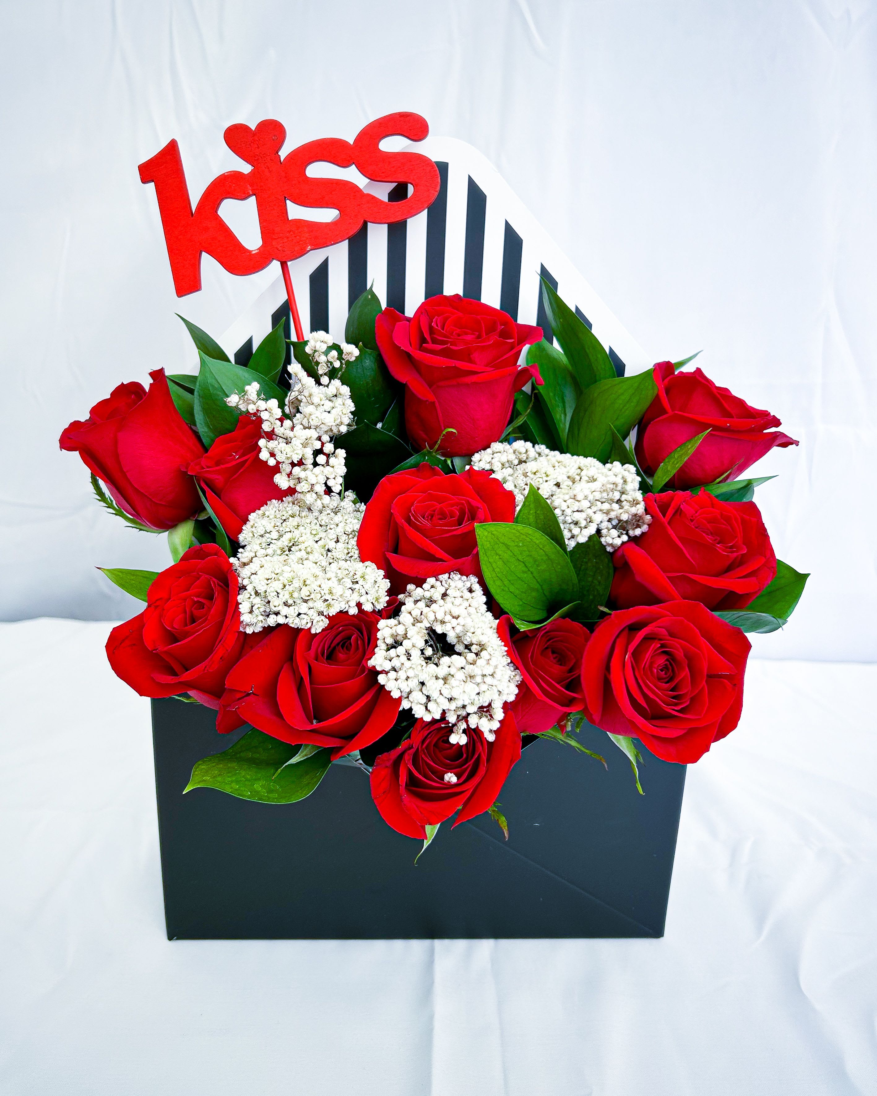 Love Letter Kiss - A romantic arrangement of premium red roses, delicate white fillers, and fresh greenery, beautifully presented in a chic envelope-style box, complete with a vibrant red kiss sign. Perfect for Valentine’s Day, anniversaries, or lover to be. Let your love speak through flowers! ️