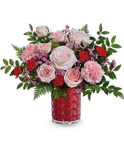 Sweetheart Sparkle Bouquet - Add a touch of sparkle to their Valentine's Day! These beautiful pink roses look stunning in this sculpted heart glass vase with a shimmering finish. This Valentine's Day arrangement features light pink roses, pink spray roses, red miniature carnations, and purple waxflower, complemented by huckleberry and leatherleaf fern. It's delivered in the Enchanted Hearts vase.