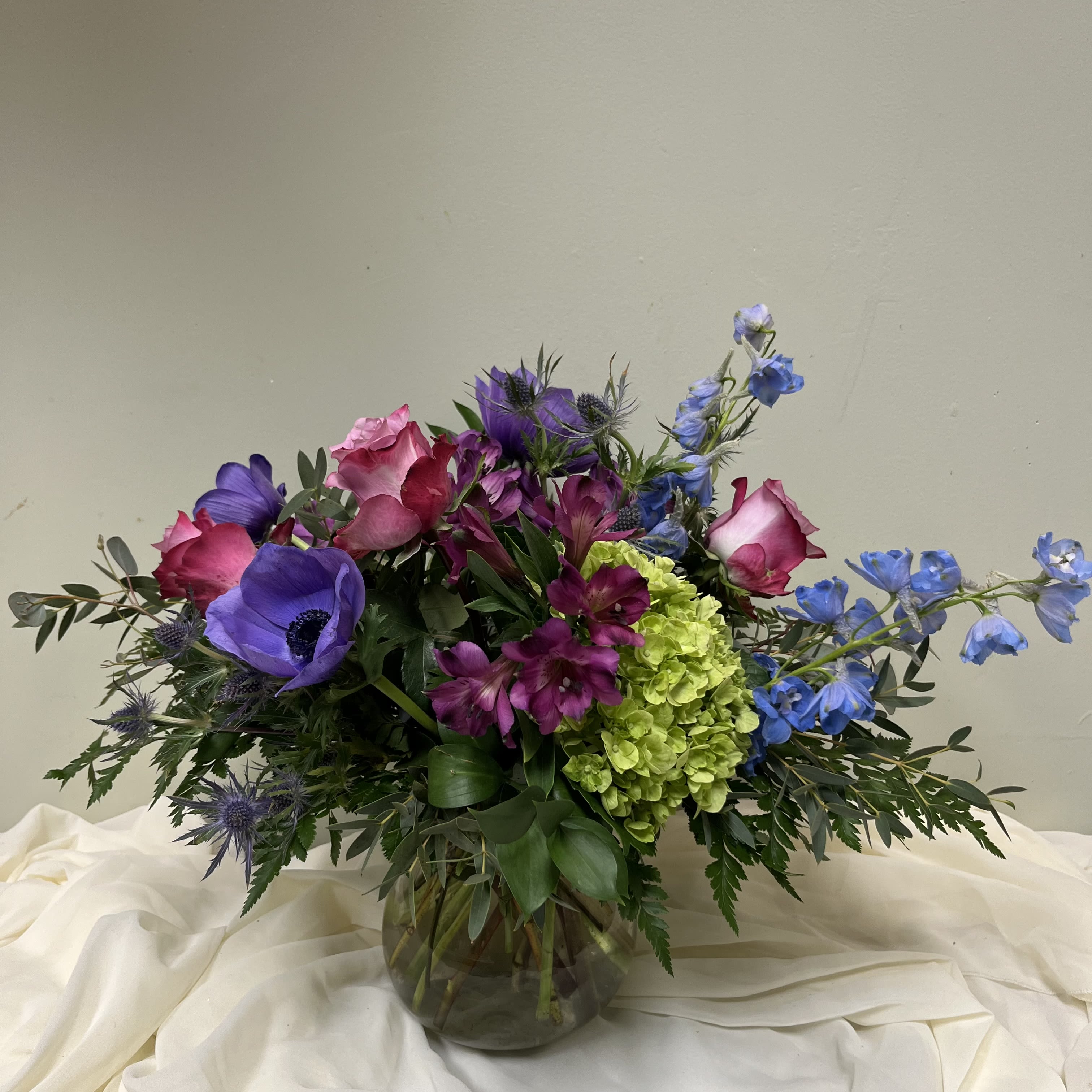 Purple Passion - Purple passion- we can sub the purple roses for anemones for the “no roses” lover.   Premium $135 adding ranunculus.  Please Note: Each design is custom made and filled to value. We only use fresh product to ensure top quality so new orders are subject to substitutions.