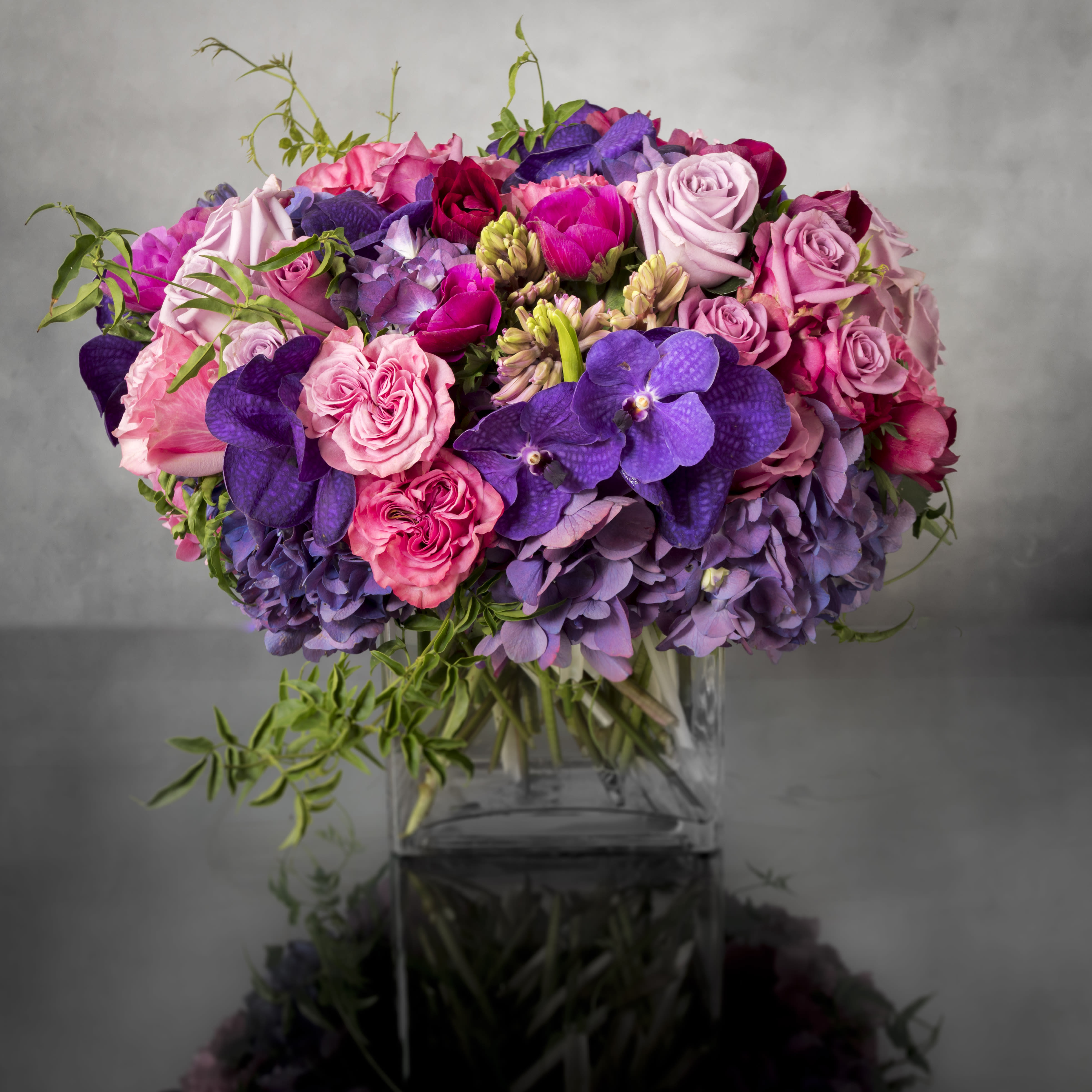 Aroma Therapy - Pasadena Florist - Touch their heart with this lavishly abundant and elegant arrangement in hues of blues, pinks, and purples. This superb design features rich Roses, luscious Orchids, and delicate clusters of Hydrangeas. A lovely gift to express your love, or to celebrate a happy occasion.  Approx: 16&quot; W x 15&quot; H