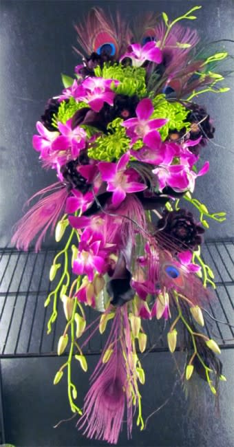 Cassidy Bridal Bouquet - Purple is such a rich, deep color while green is a great fun pop of color! Here is our exclusive Cascade Bride's Bouquet featuring Bombay Dendrobium Orchids, Schwarzwalder Mini Calla Lilies, Spider Mums, Dahlias, Curly Willow and Feathers.  All of our wedding work is custom and we can create any bouquet you've always wanted. contact us online or call us at 619-237-8842 to discuss color options or to schedule a complimentary wedding consultation with one of our wedding designers, you will be glad you did!