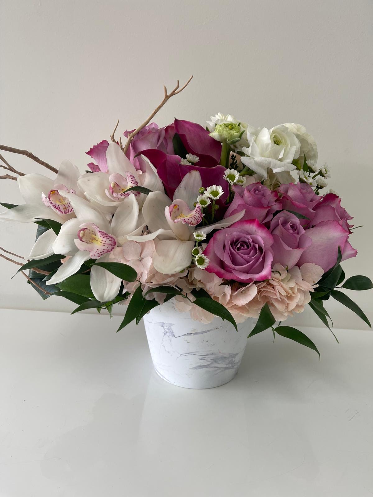 Joy - Designer arrangement with lavender pink roses, orchids and greens in a beautiful keepsake vase. 