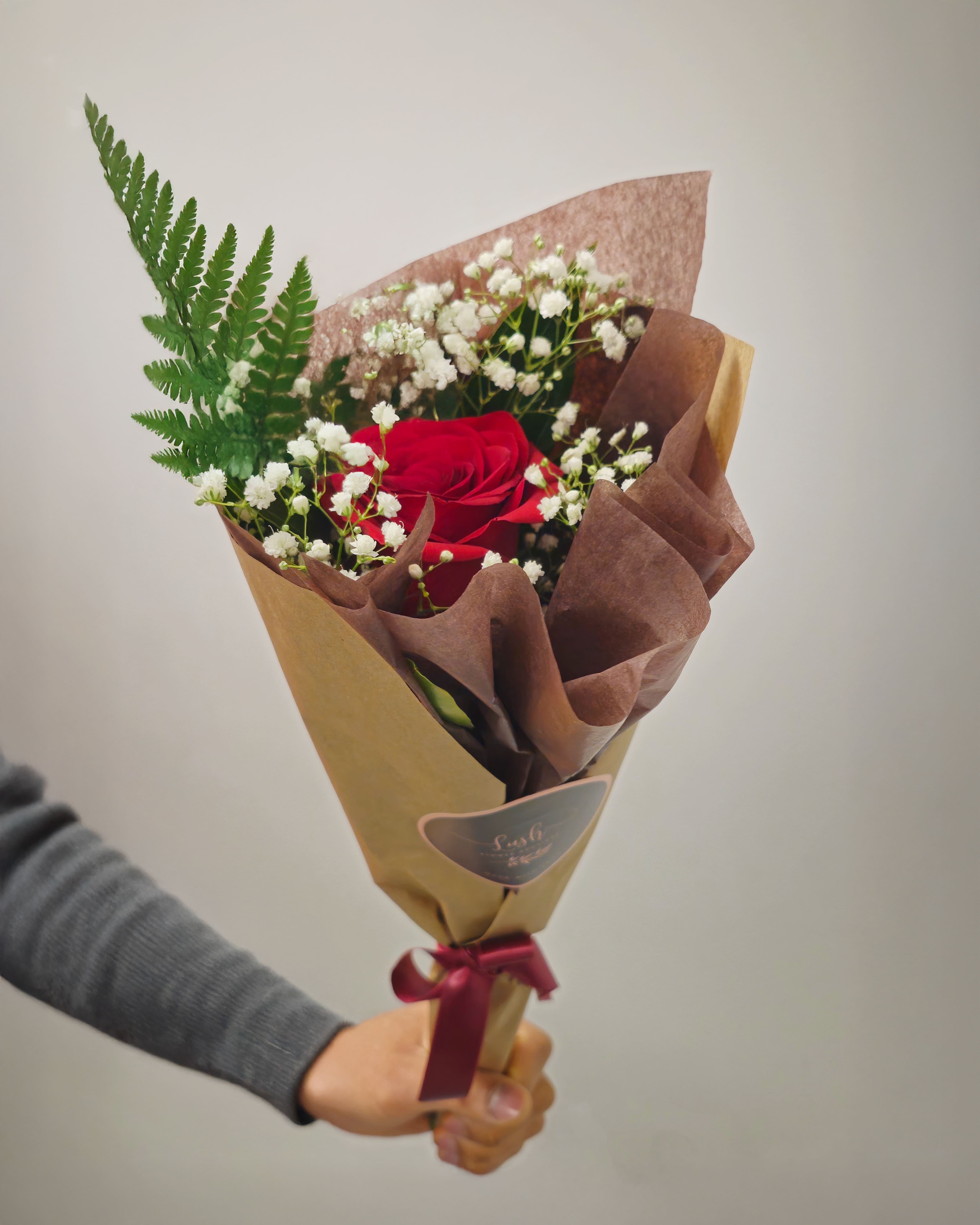 Single Rose Bouquet - A timeless Valentine’s Day gift featuring a single red premium rose, delicate baby’s breath, and lush greenery, elegantly arranged in custom wrapping. Simple yet meaningful, it’s a perfect way to express love and admiration.