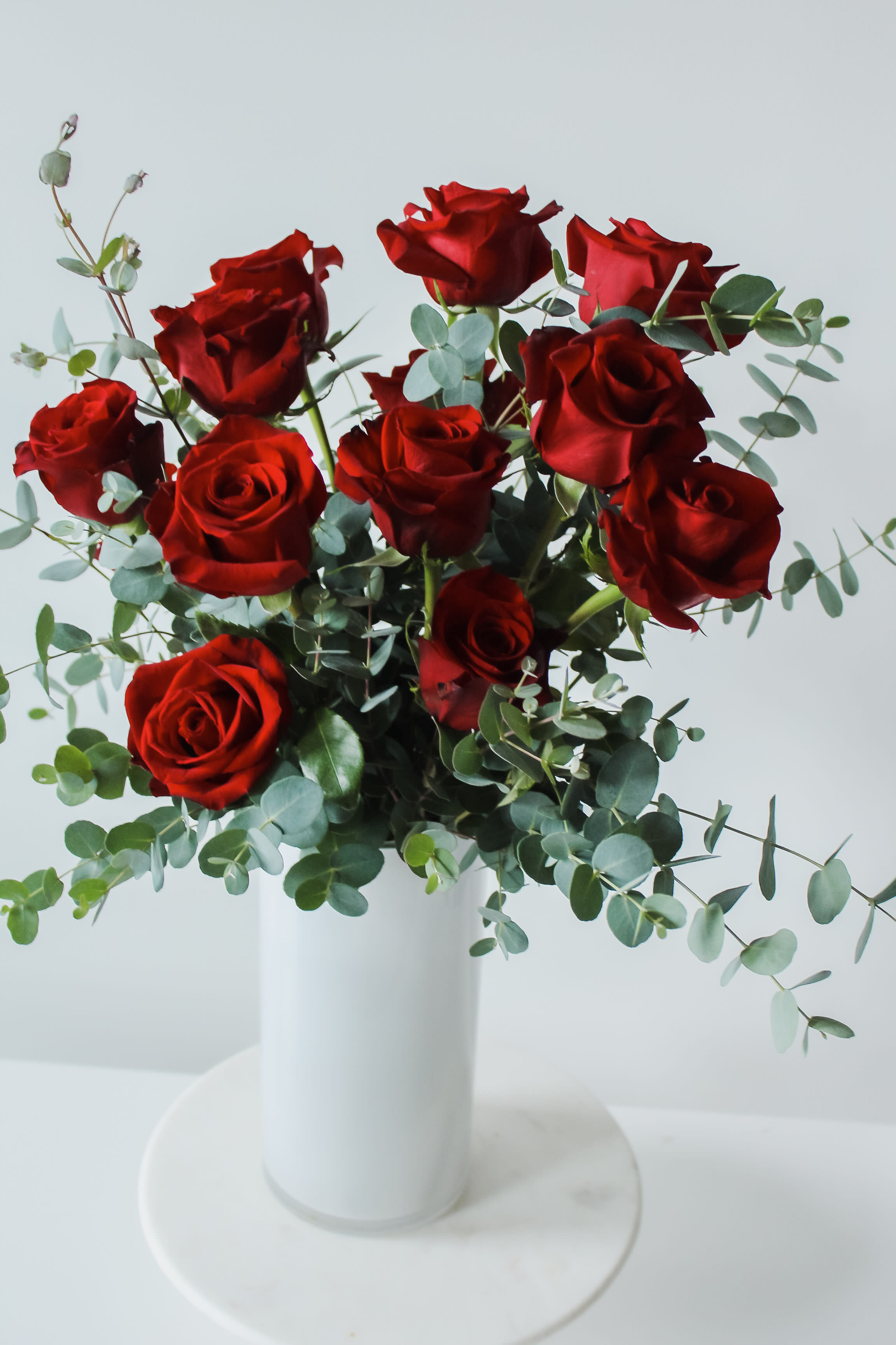 Classic Dozen Classic Dozen - Send you love with our classic dozen long stem red roses floating among eucalyptus in our signature white cylinder.