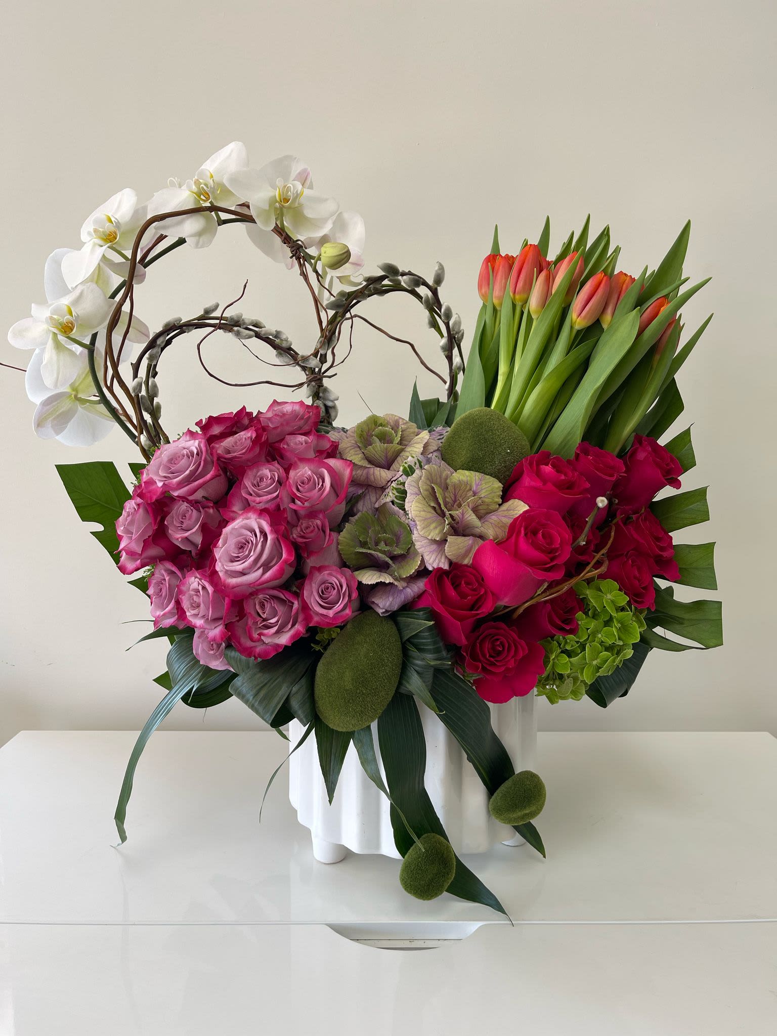 Heather Heather - Designer arrangement of fresh roses, orchids, tulips, and hydrangeas uniquely combined in a keepsake white vase.