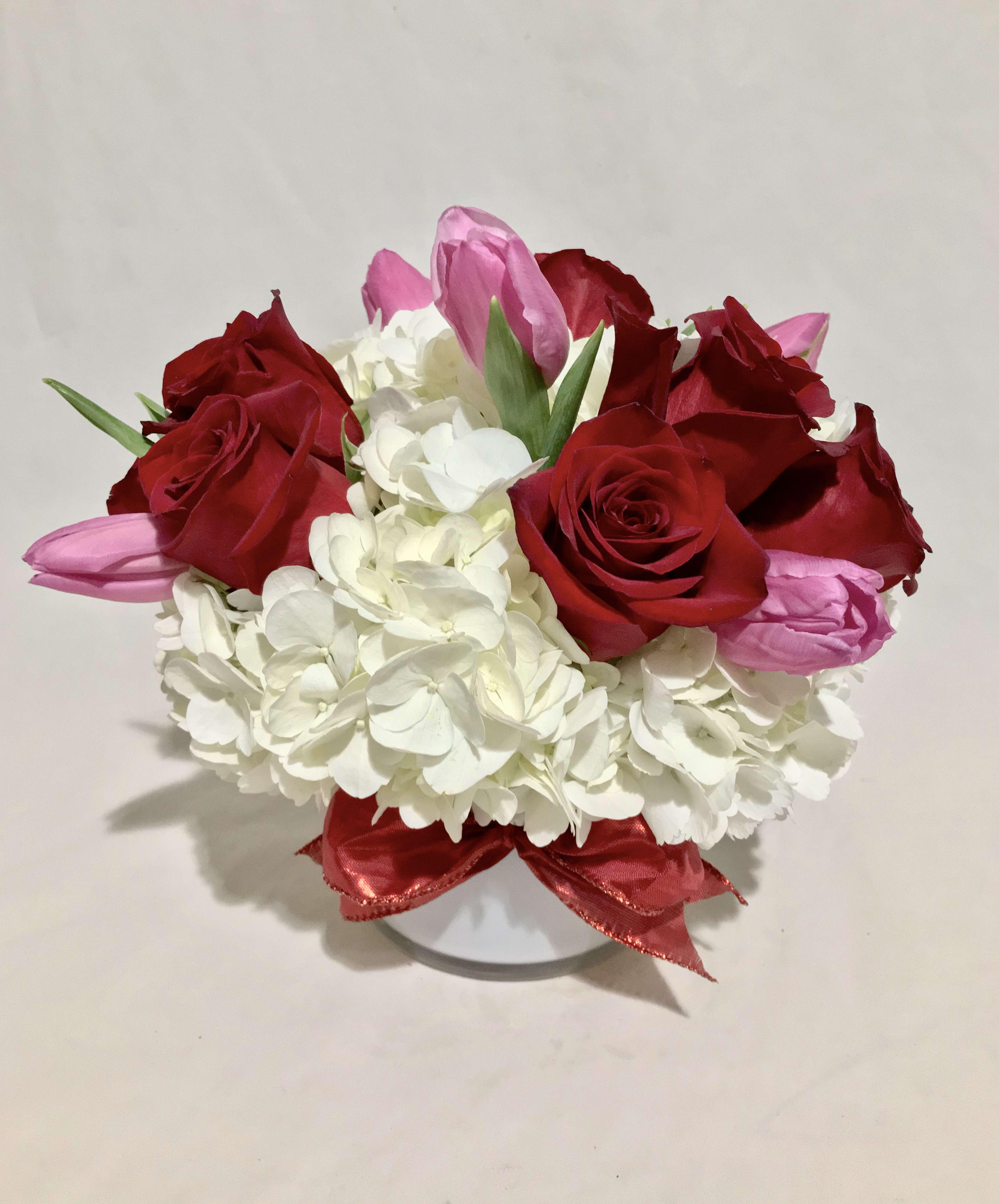 Blossoming Romance Blossoming Romance - Blossoming Romance by BloomNation™ is the perfect gift to wish someone a happy birthday or to say thank you. Arrangement Details: This arrangement includes red roses, pink tulips, and white hydrangea in a white cylinder vase. APPROXIMATE DIMENSIONS: 12" H X 11" W